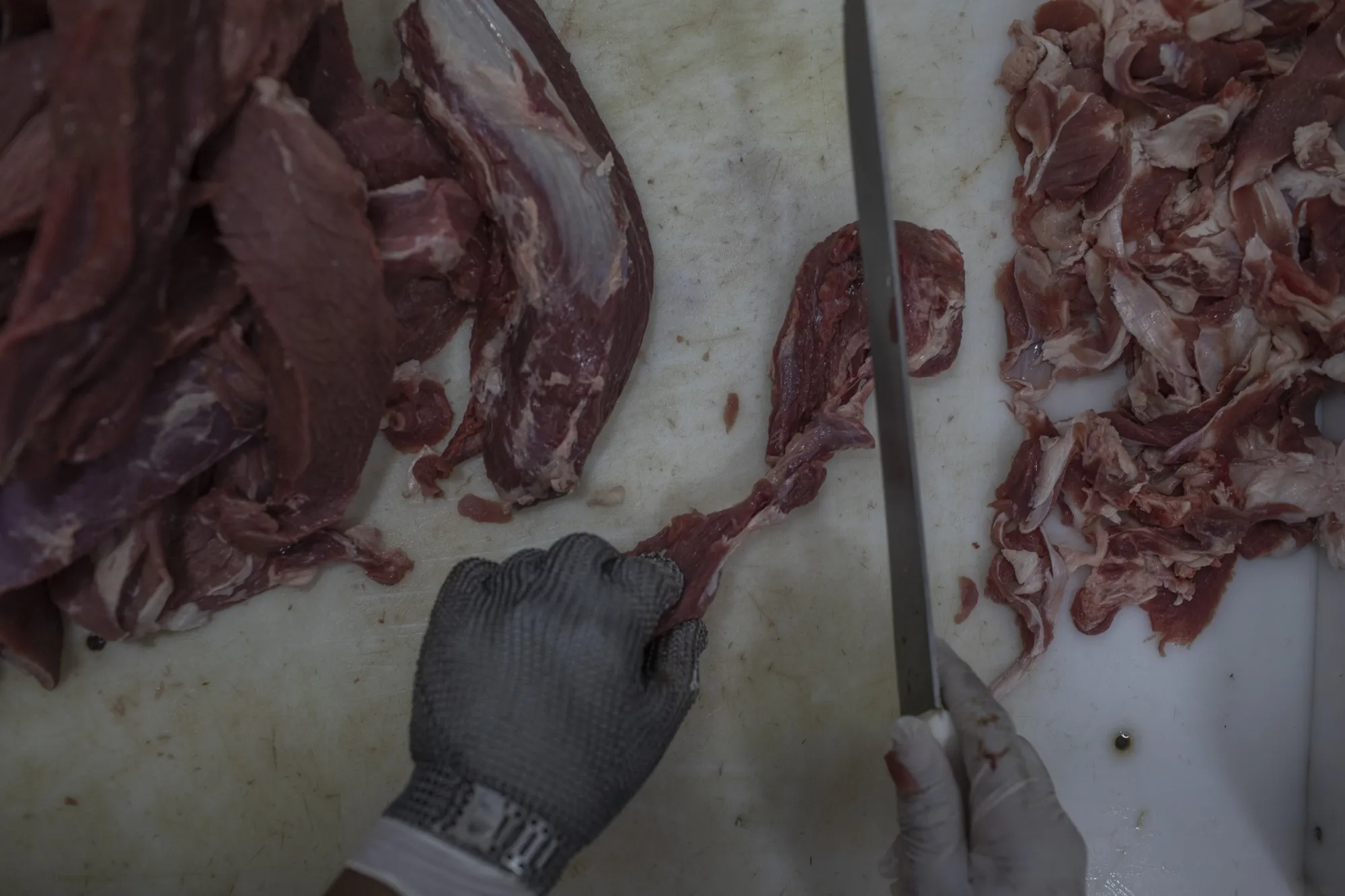 A butcher cuts meat at a grocery store in Brasilia, Brazil.