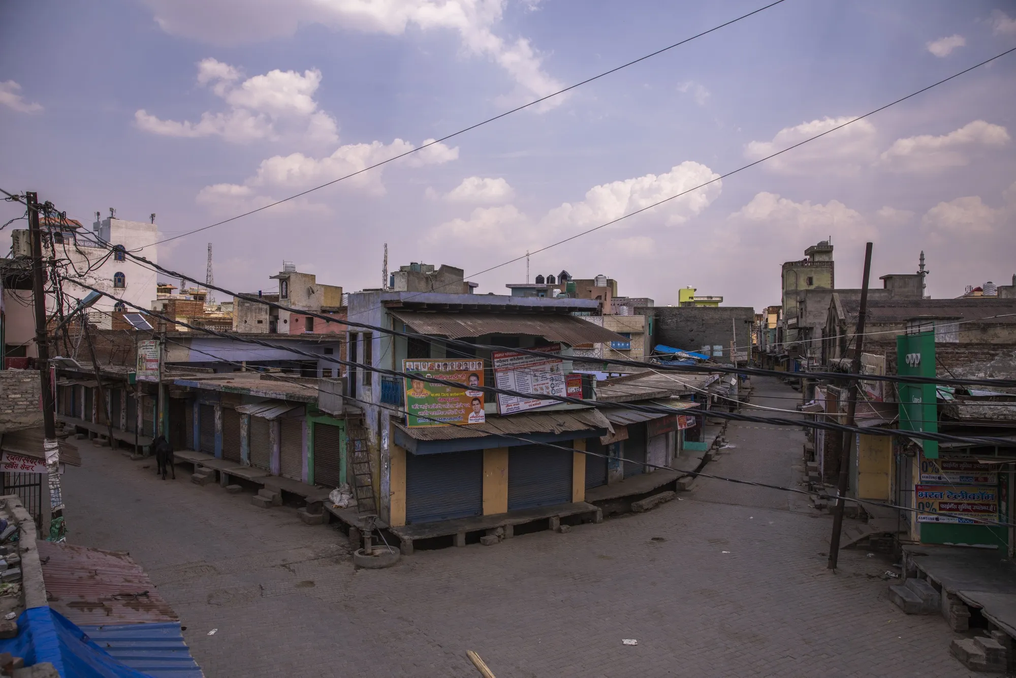Stores and businesses stand shuttered on a deserted street during a partial lockdown imposed due to the coronavirus at a town in the Gautam Buddh Nagar district of Uttar Pradesh, India.