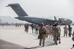 Evacuees escorted on to a U.S. Air Force Boeing C-17 Globemaster III during an evacuation at Hamid Karzai International Airport, Kabul, Afghanistan, Aug. 21.