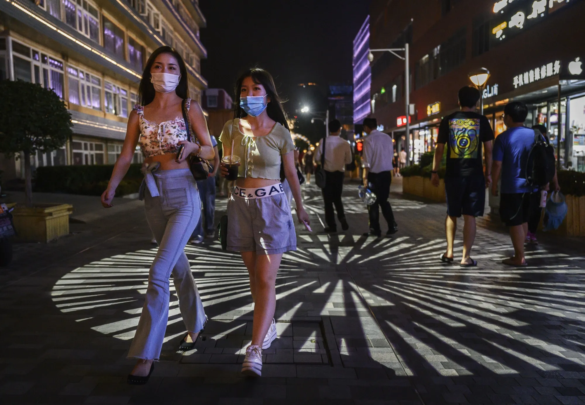 People wear protective masks at a shopping area in Beijing on Aug. 14.