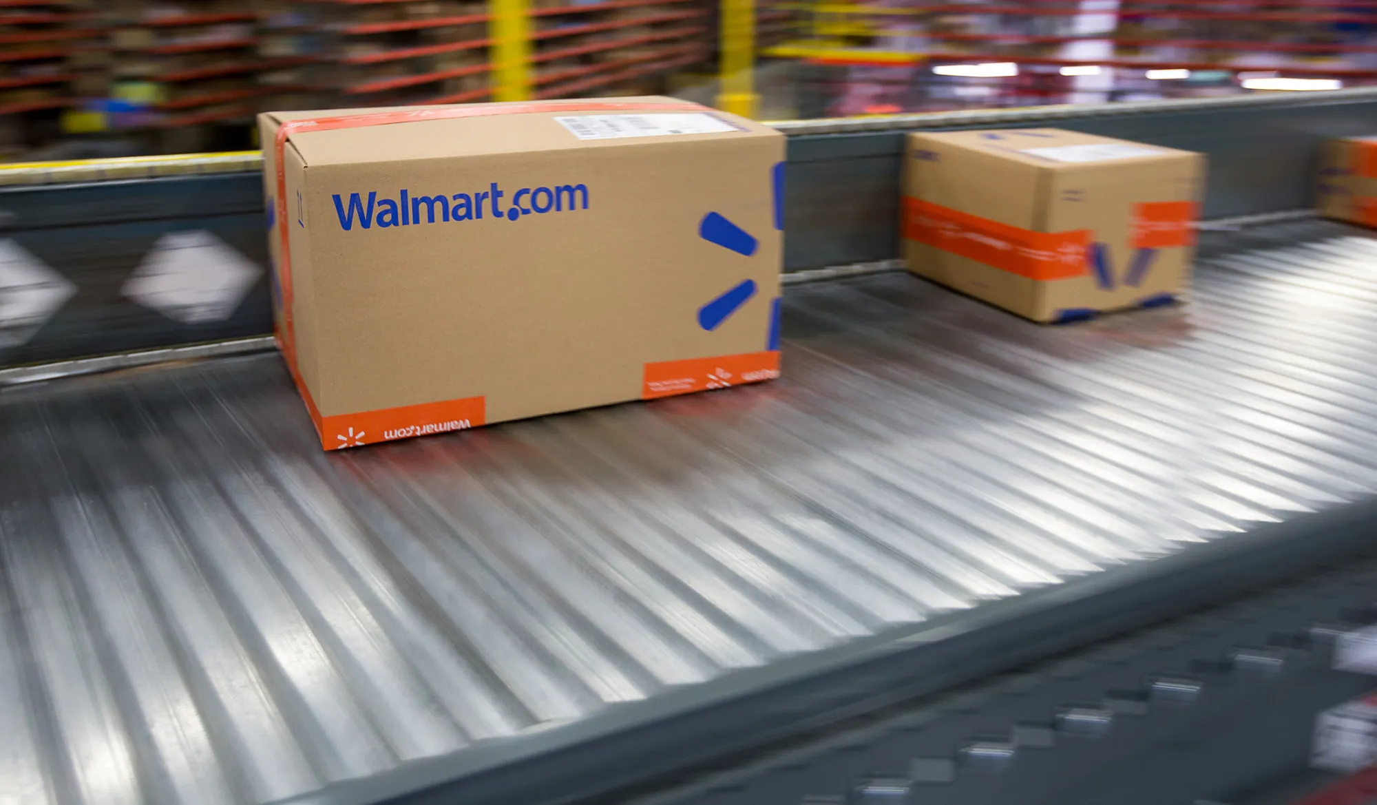 Packages move along a conveyor belt inside a Wal-Mart Stores Inc. fulfillment center in Bethlehem, Pennsylvania, U.S., on Wednesday, March 29, 2017. Wal-Mart Stores Inc. acquired e-commerce startupJet.com for $3.3 billion in cash and stock. Jet.com Founder and his management team wereput in chargeof Wal-Mart's entire domestic e-commerce operation, overseeing more than 15,000 employees in Silicon Valley, Boston, Omaha, and its home office in Arkansas. Photographer: Michael Nagle/Bloomberg
