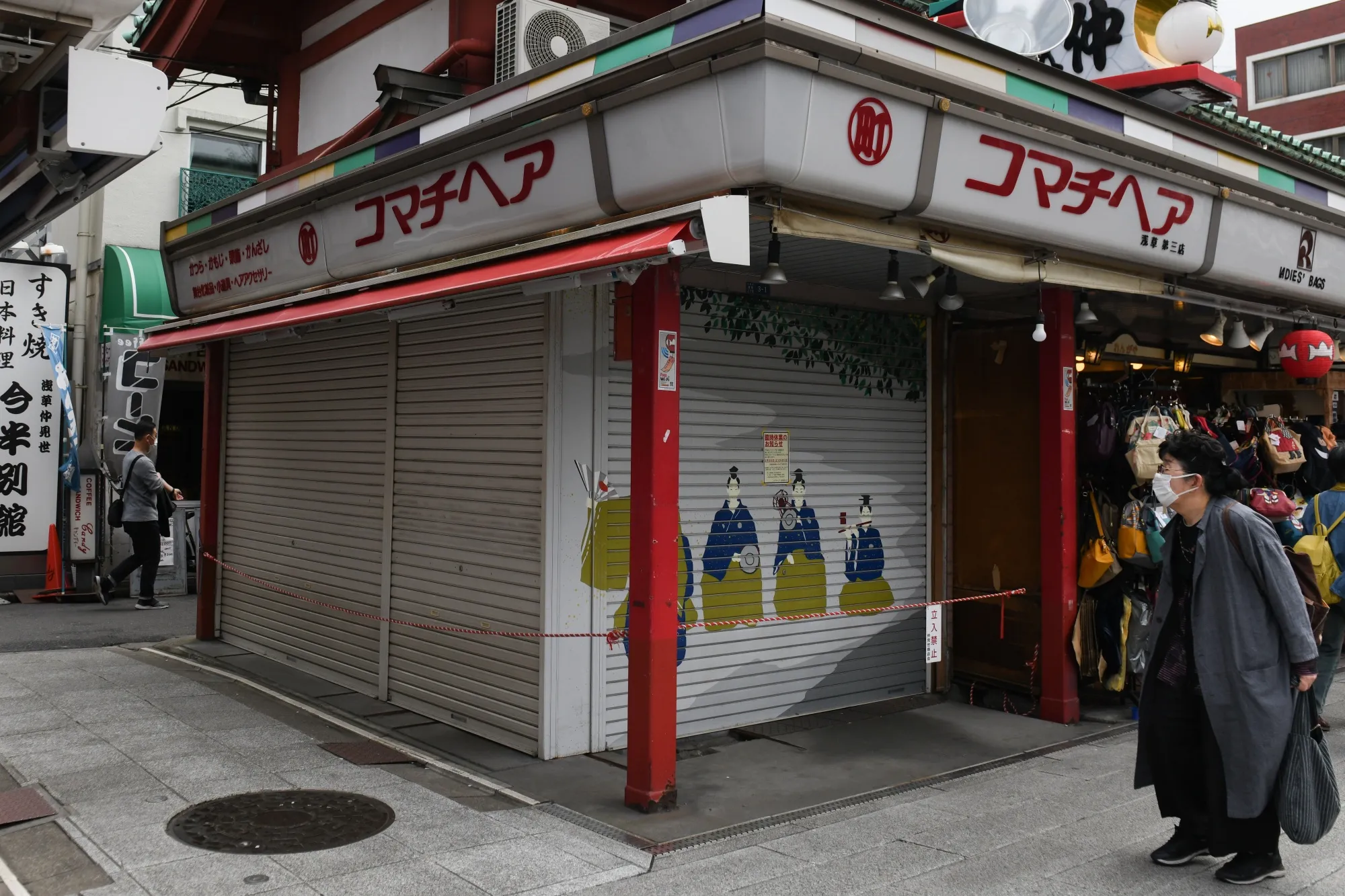 A pedestrian looks at a sign indicating the temporary closure of a store in Nakamise street in Tokyo, on March 28.