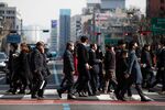 Pedestrians wearing protective masks cross a road in Seoul, South Korea, on Monday, Feb. 24, 2020.