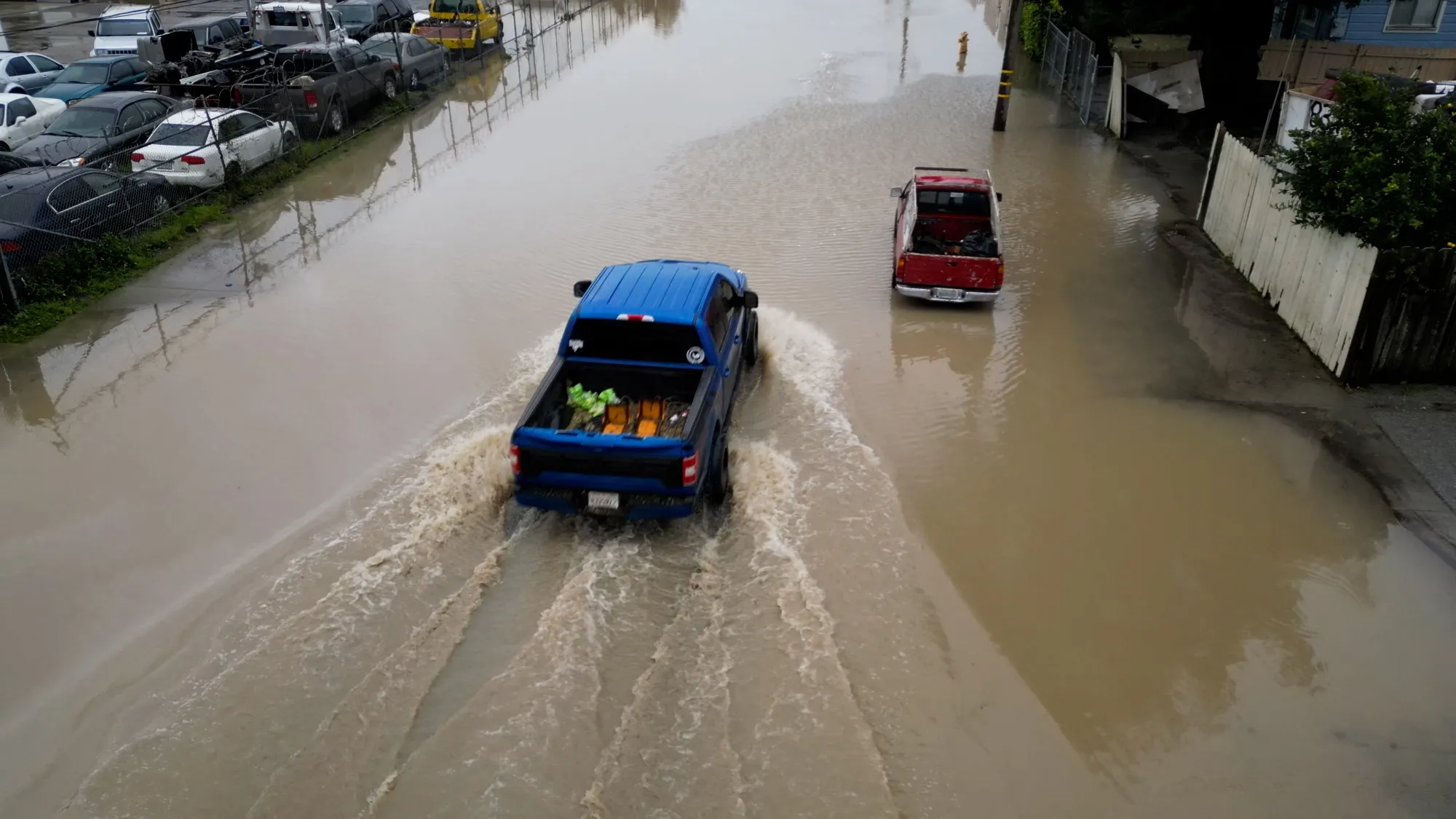 Trucks driving through a flooded street in Pajaro, California, on March 14.