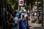 A pedestrian uses a towel on their head to protect against the heat in&nbsp;Barcelona in 2021.