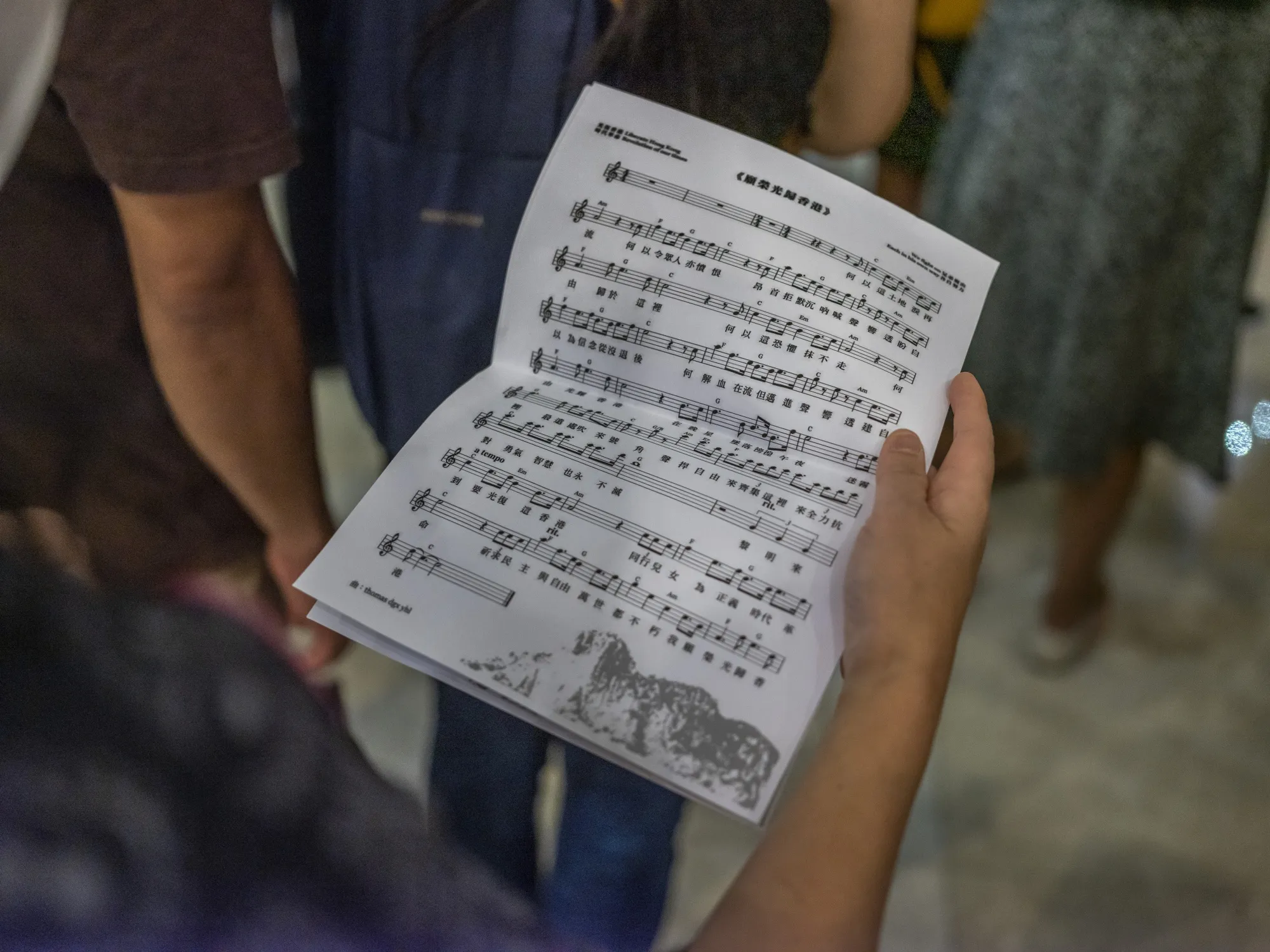 A demonstrator holds the music score while singing "Glory To Be Thee, Hong Kong" protest song during a flash mob protest in 2019.