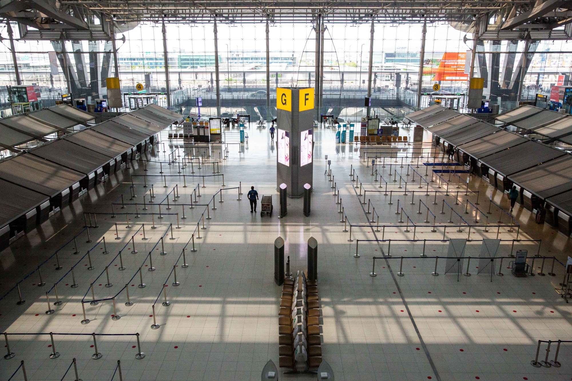 Airport staff walk through an empty Suvarnabhumi Airport departure hall in Bangkok on April 3.