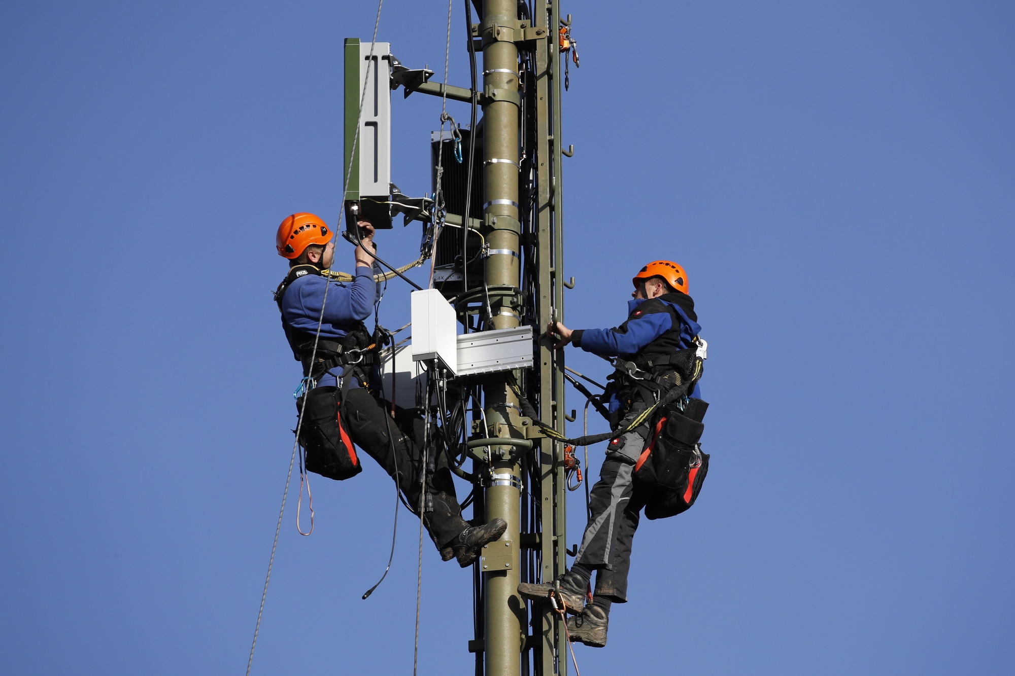 Engineers scale a Swisscom AG telecommunication network mast to install Ericsson AB 5G apparatus in Hindelbank, Switzerland.