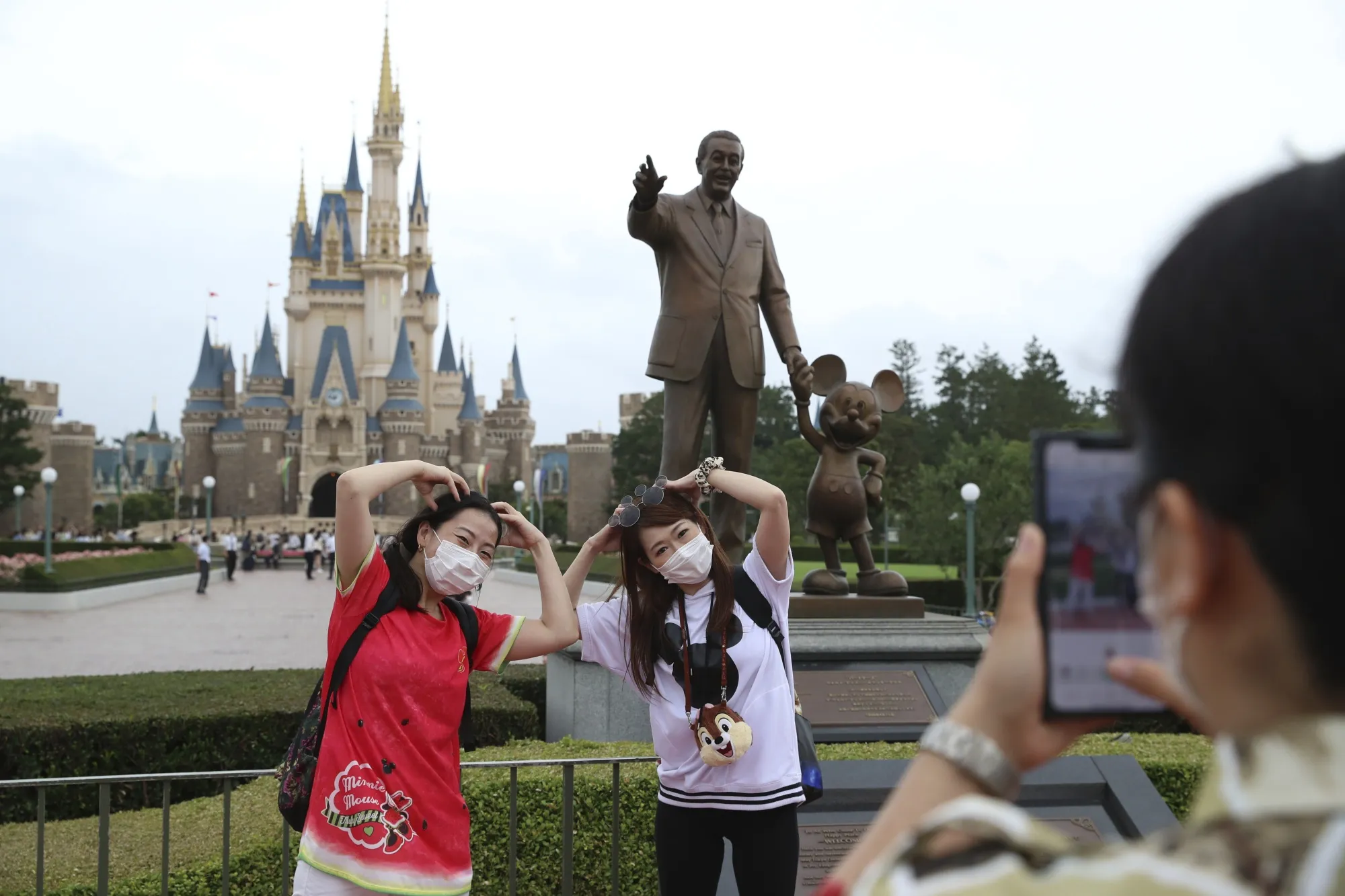 Visitors pose for a photograph at Tokyo Disneyland on July 1.