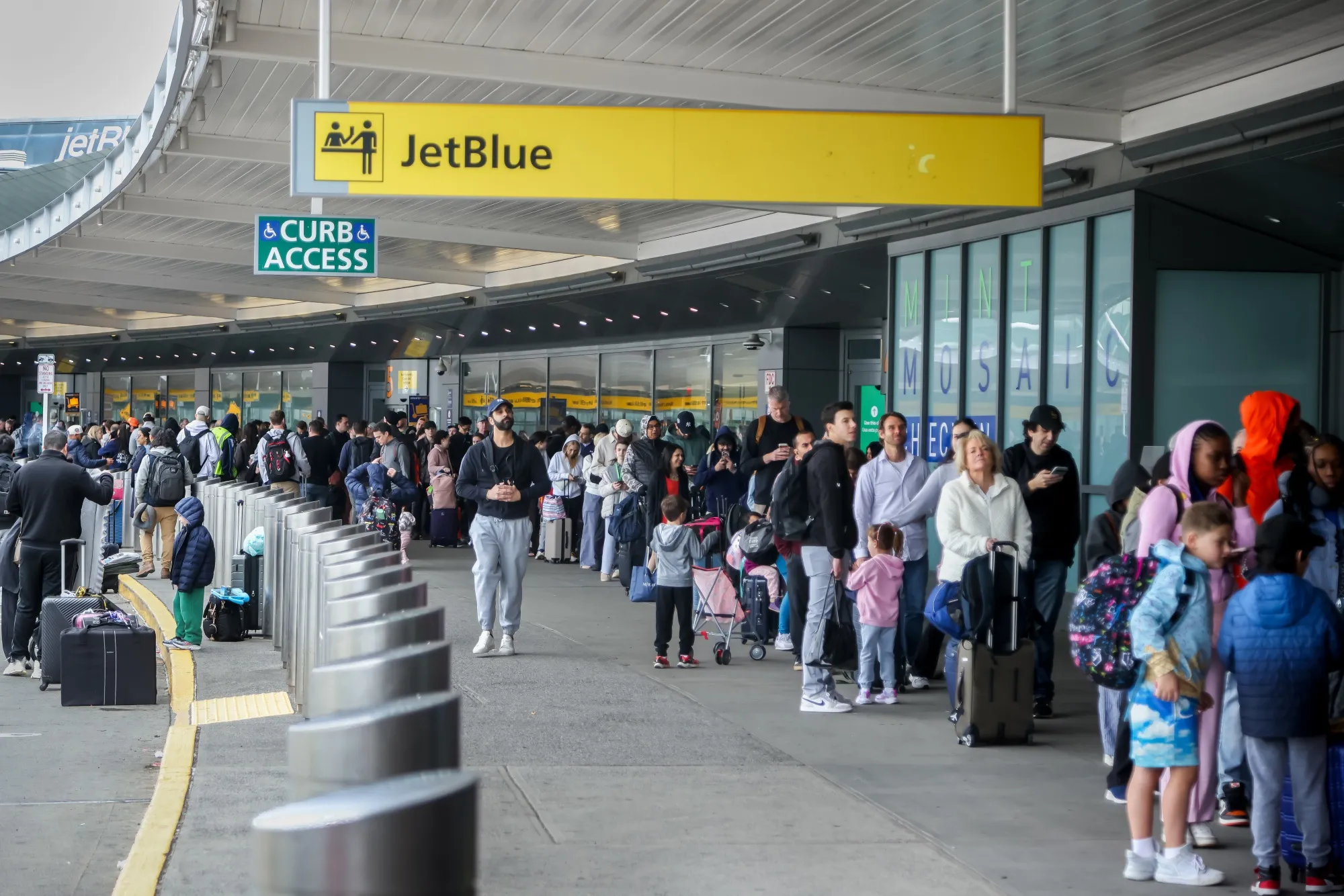 Travelers wait in line at a Transportation Security Administration (TSA) checkpoint at John F. Kennedy International Airport (JFK) in New York, US, on Friday, March 27, 2026. Several of President Donald Trump’s closest allies in the House are resisting swift passage of legislation to end a partial government shutdown that has snarled air traffic and threatened to ripple through an economy already roiled by the Iran war.