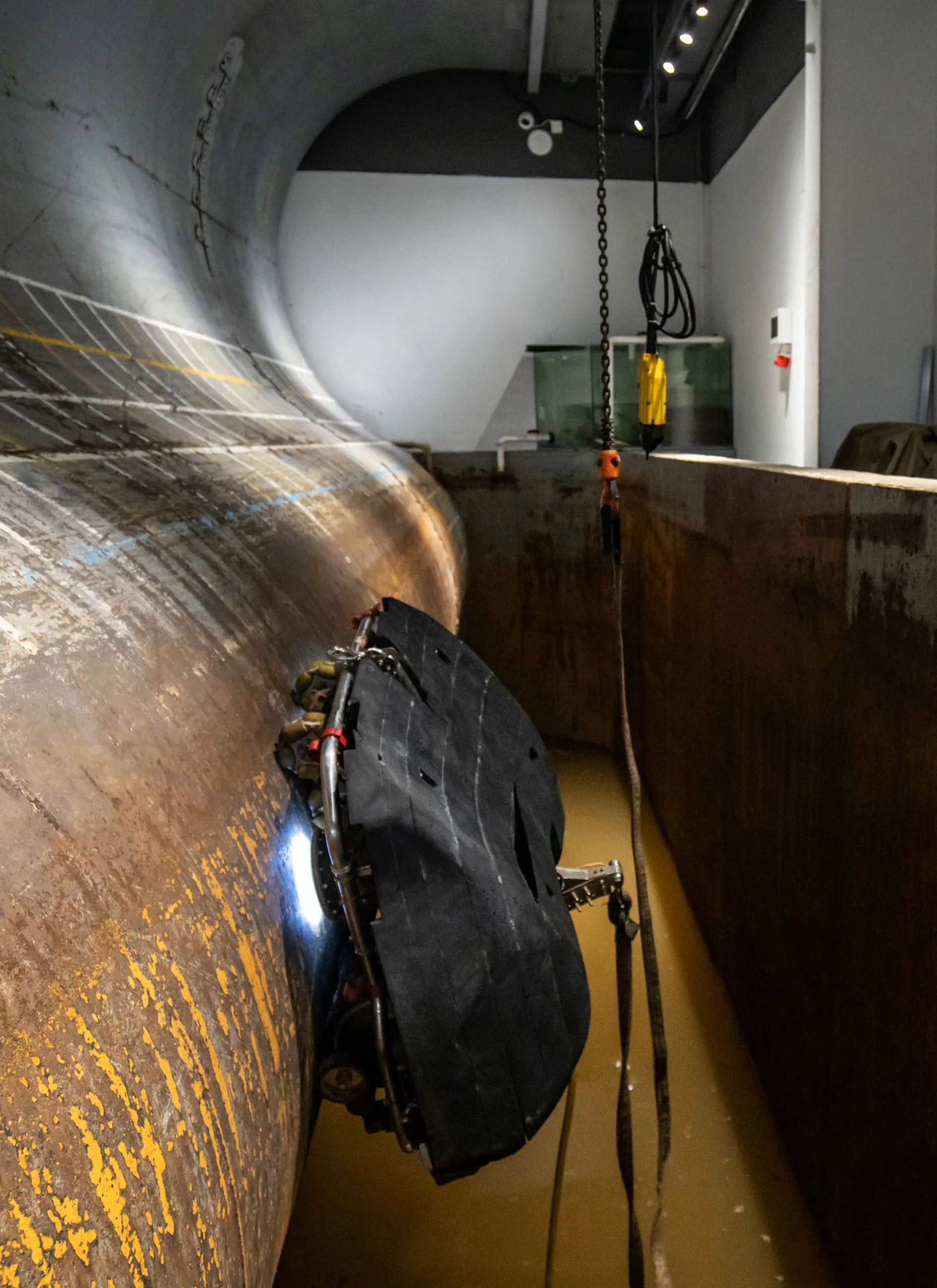 A demo at the Neptune Robotics facility in Shenzhen shows one of the company's robots in a room built to simulate the curvature of a ship’s hull and&nbsp;muddy water conditions.