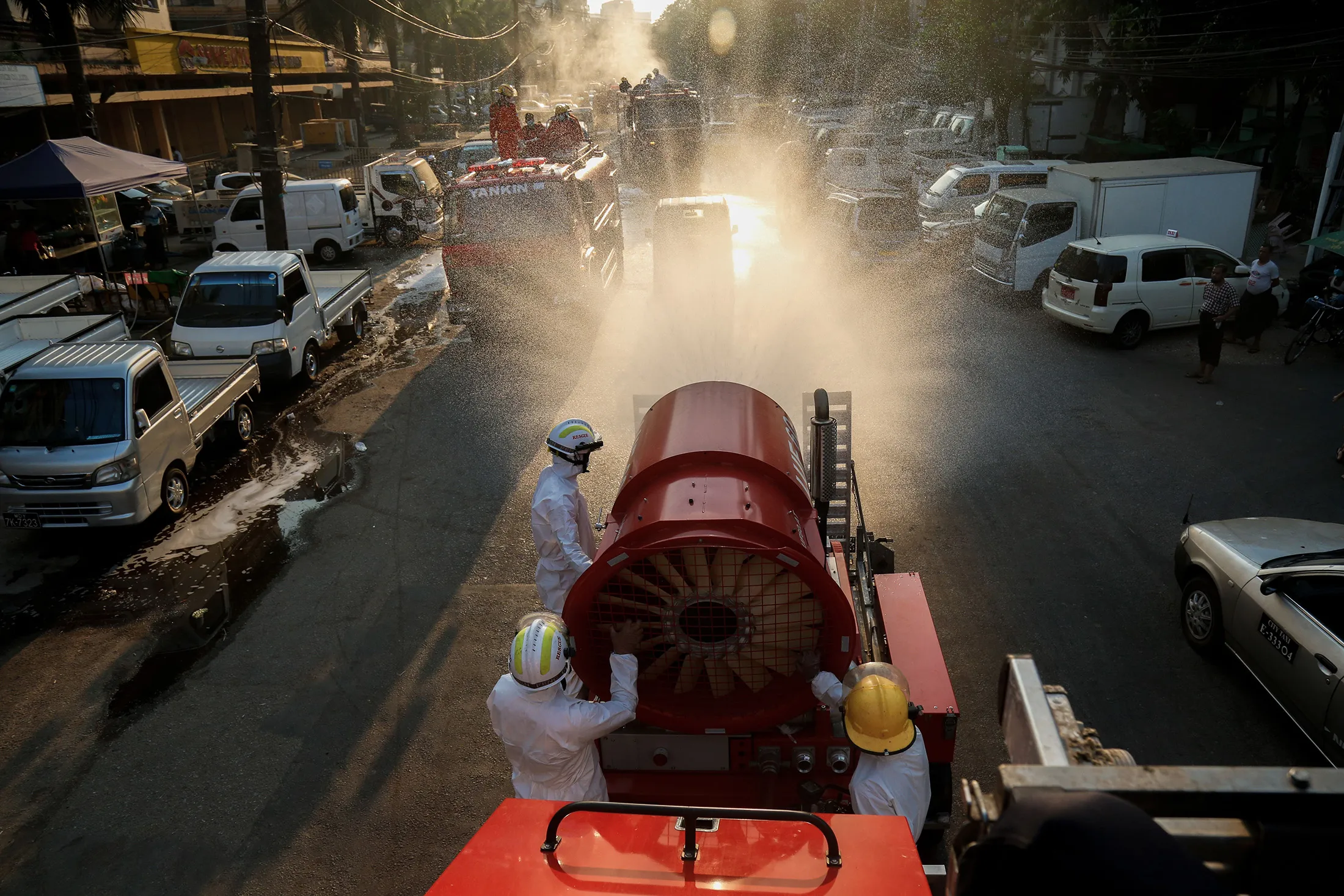 Firefighters wearing protective clothing spray disinfectant along a street as a preventive measure against the spread of&nbsp;Covid-19 in Yangon, Myanmar on April 23.