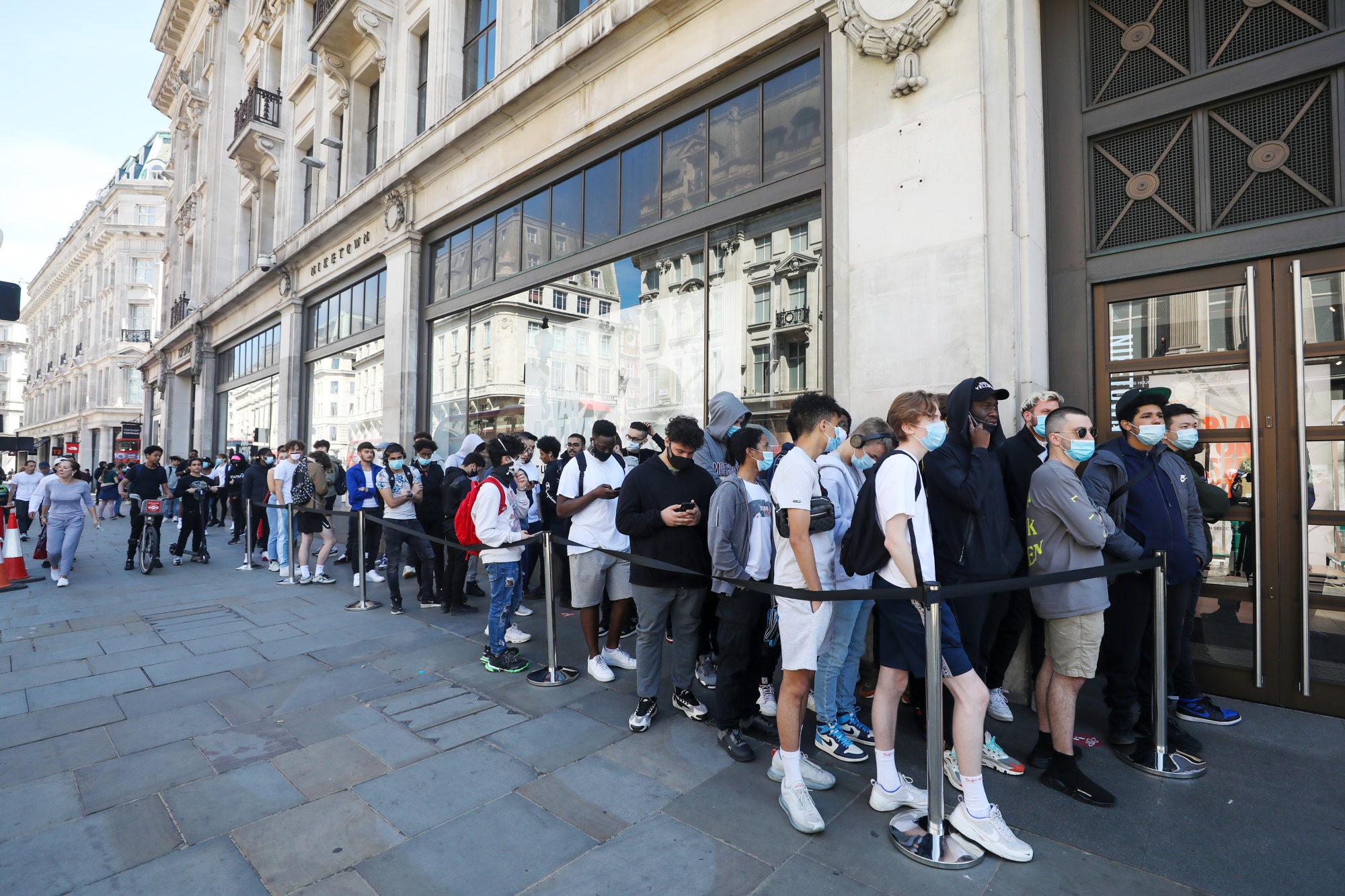 Customers stand in line outside a Louis Vuitton store, operated by News  Photo - Getty Images