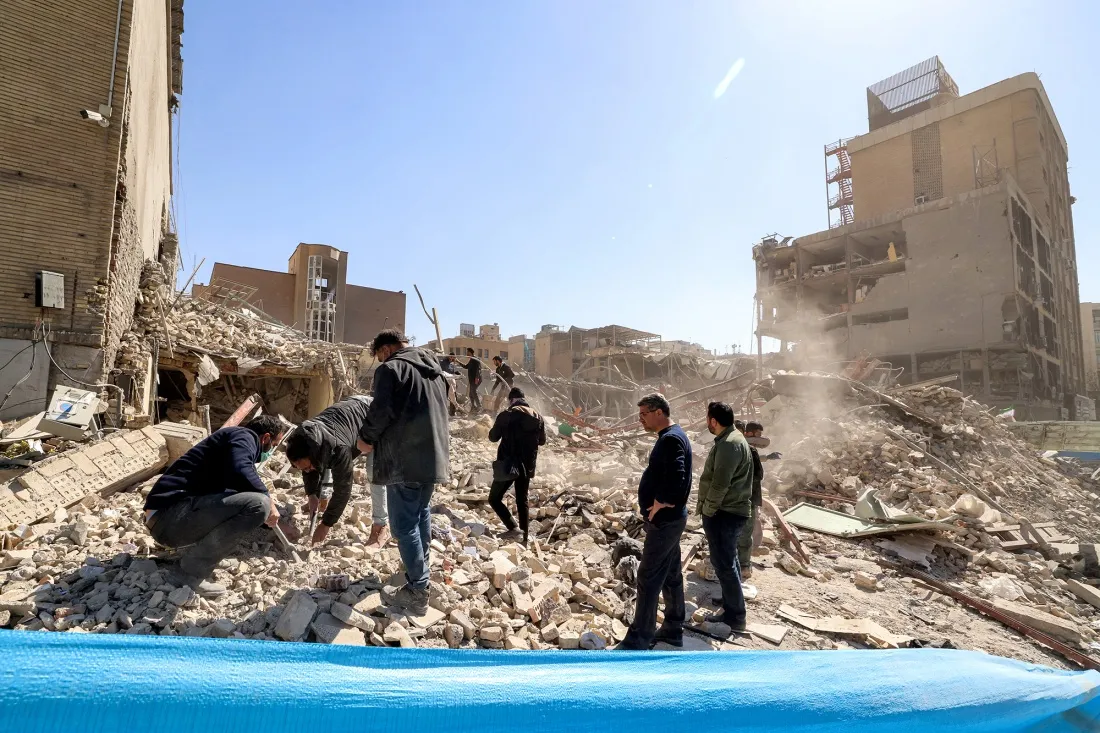 People inspect the rubble of a collapsed building near Ferdowsi square in Tehran on March 3.