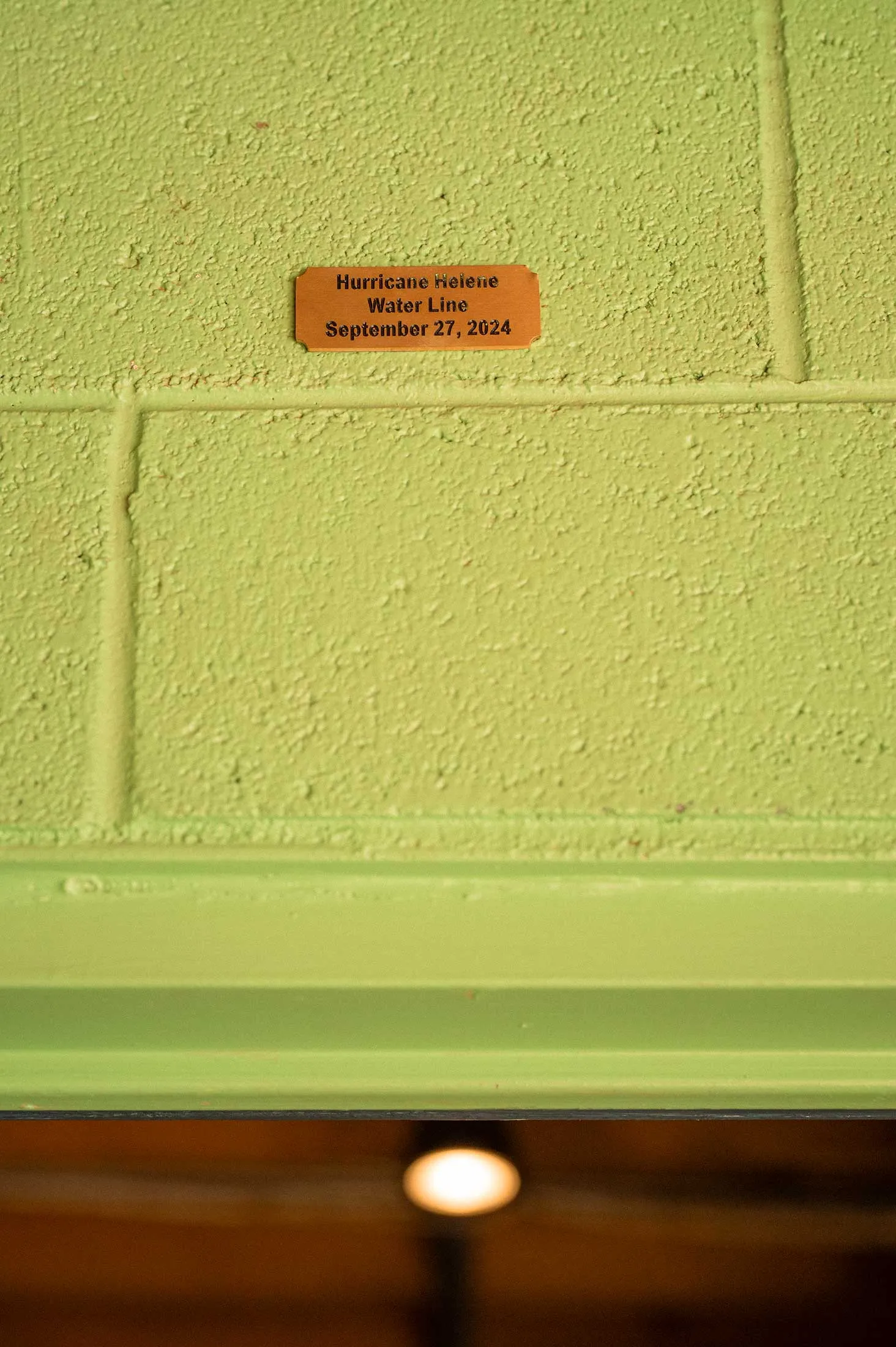 A plaque high above a doorway at High Wire Brewery River Arts District location shows the water line from hurricane Helene.