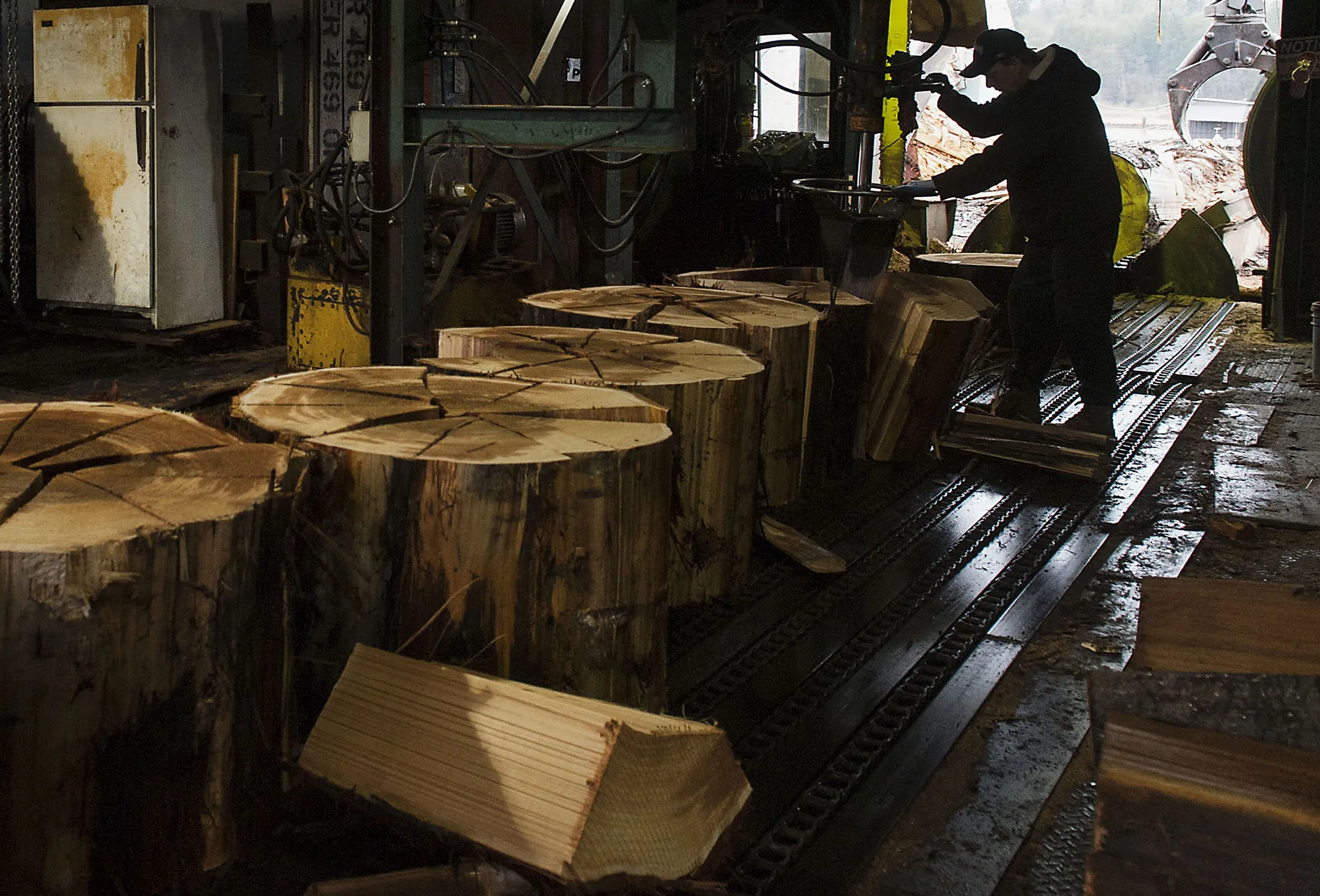 A worker splits cedar logs to manufacture shakes and singles at a facility in Maple Ridge, British Columbia, Canada.
