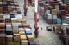 A worker walks past shipping containers sitting stacked at the Yangshan Deepwater Port, operated by Shanghai International Port Group Co. (SIPG), in Shanghai, China, on Friday, May 10, 2019. The U.S. hiked tariffs on more than $200 billion in goods from China on Friday in the most dramatic step yet of President Donald Trump's push to extract trade concessions, deepening a conflict that has roiled financial markets and cast a shadow over the global economy.
