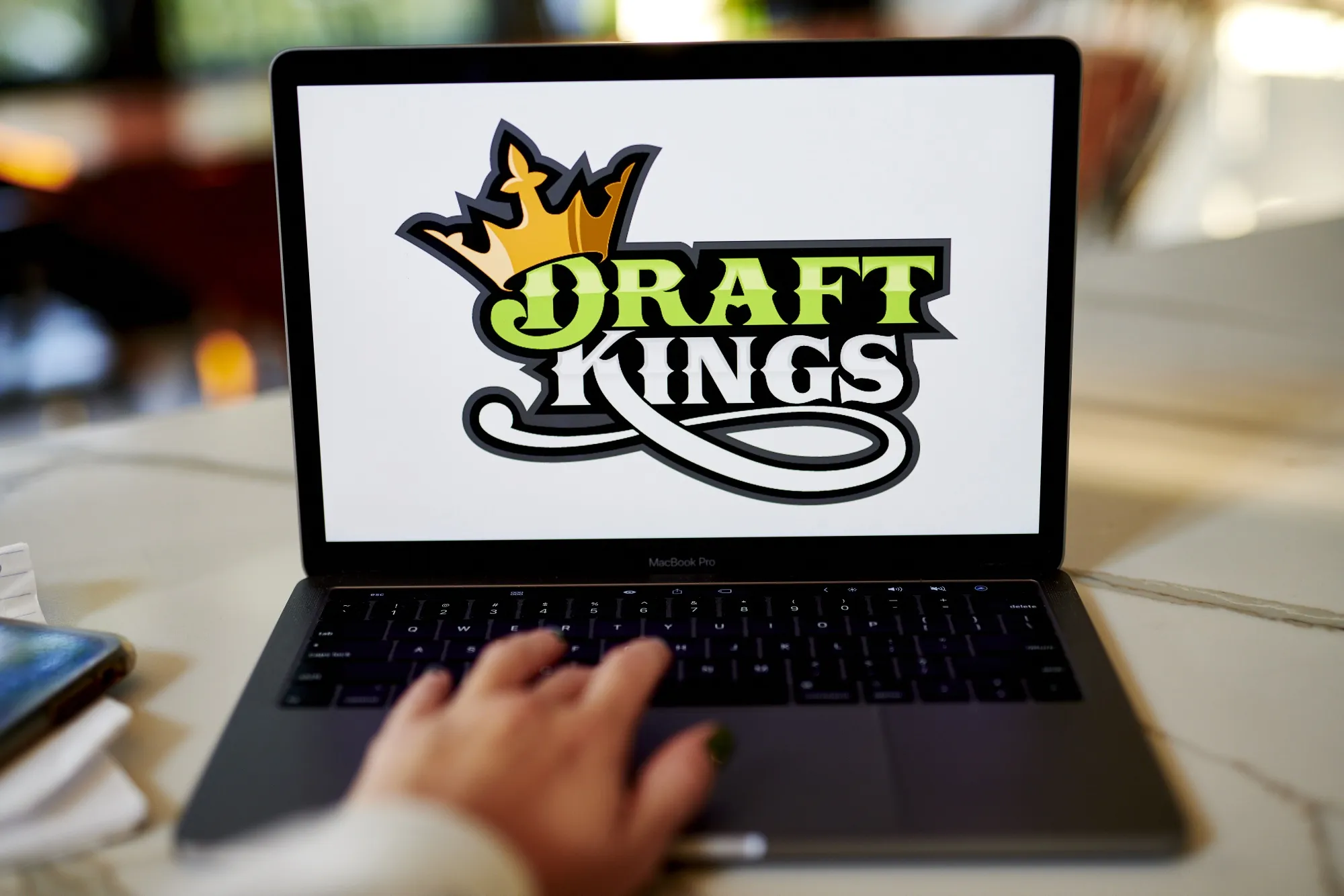 The logo for DraftKings is displayed on a laptop computer.