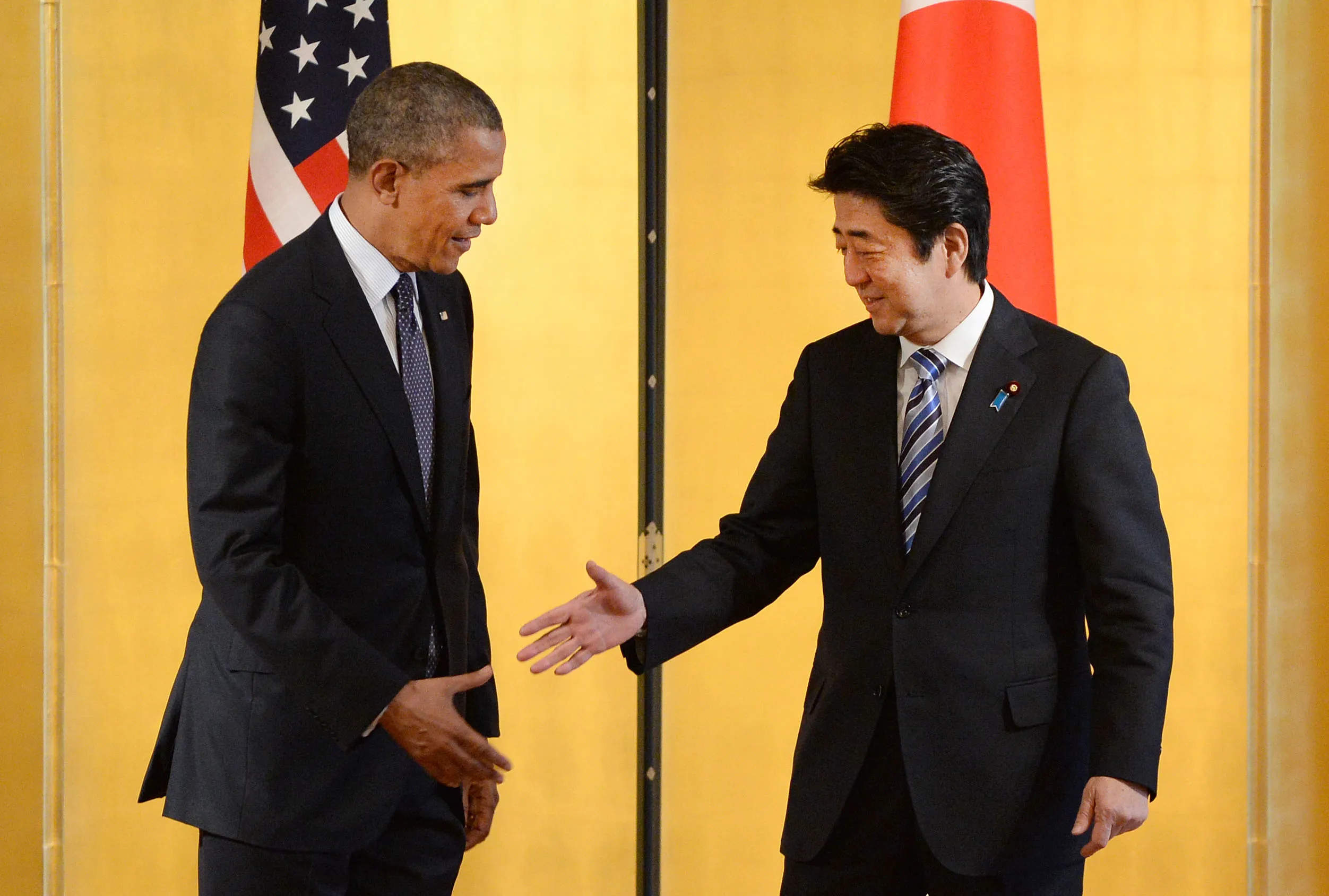 U.S. President Barack Obama, left, reach out to shake hands with Shinzo Abe, Japan's prime minister, before their meeting at the State Guest House in Tokyo on April 24, 2014.
