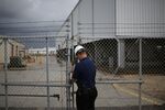 A security officer locks a gate at the Bryan Mound Strategic Petroleum Reserve in Freeport, Texas.