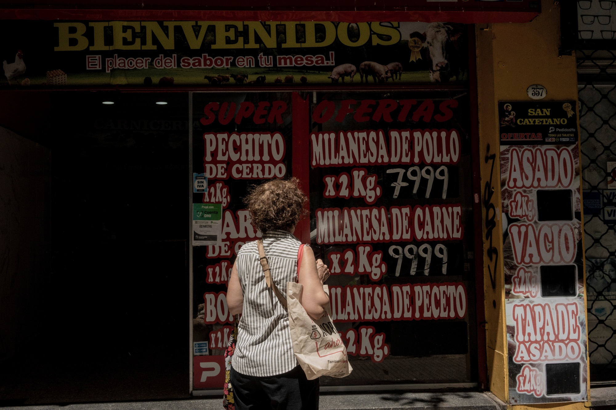 A shopper looks at prices displayed at butcher shop in Buenos Aires, Argentina.
