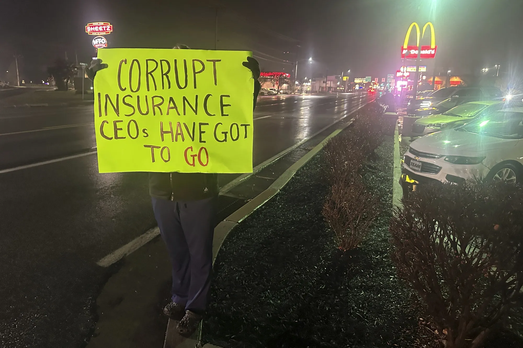 A person holds up a sign in front of the McDonald’s restaurant where police earlier in the day arrested Luigi Mangione in Altoona, Pennsylvania, on Dec. 9.