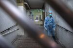 A police officer wearing protective gear stands guard behind a gate at the Hong Mei House residential building of Cheung Hong Estate in the Tsing Yi district of Hong Kong, China.
