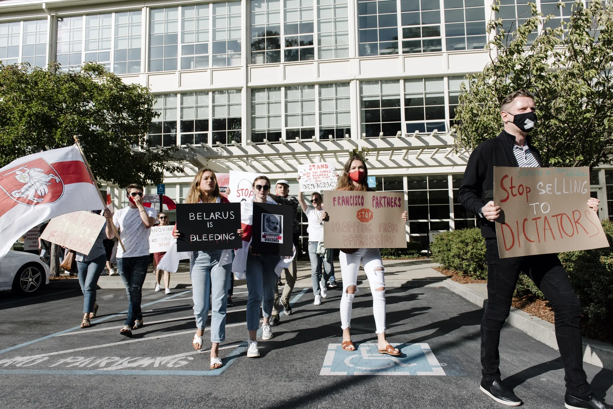 Demonstrators hold signs and wave a Belarus flag during a protest outside Francisco Partners headquarters in San Francisco, California, U.S., in 2020. The government of Belarus shut down access to much of the internet during a crucial election in August by using equipment manufactured by Sandvine Inc.