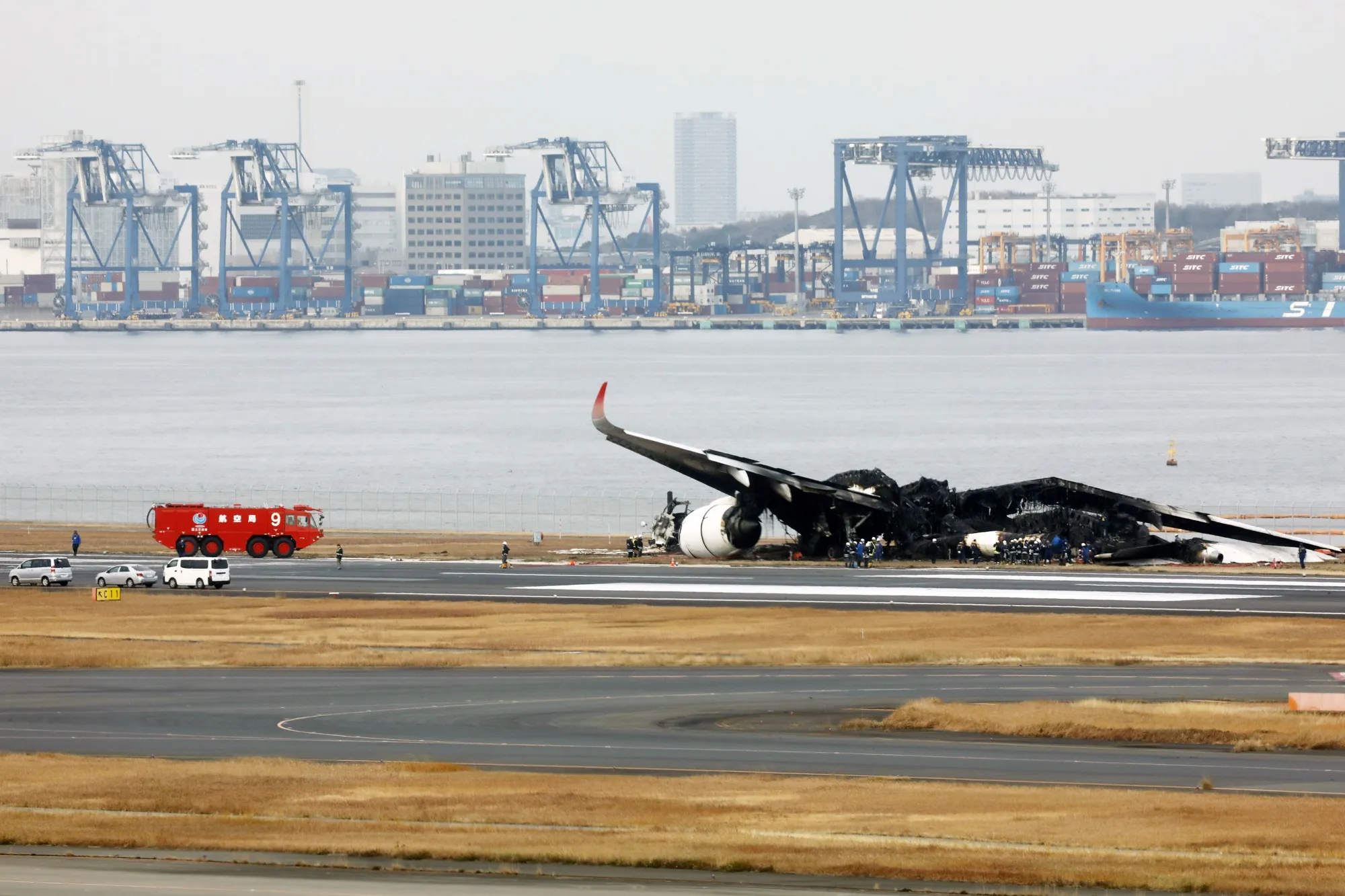 Officials investigate the wreckage of a Japan Airlines Co. aircraft that caught fire&nbsp;on the runway at Haneda Airport in Tokyo, Japan.