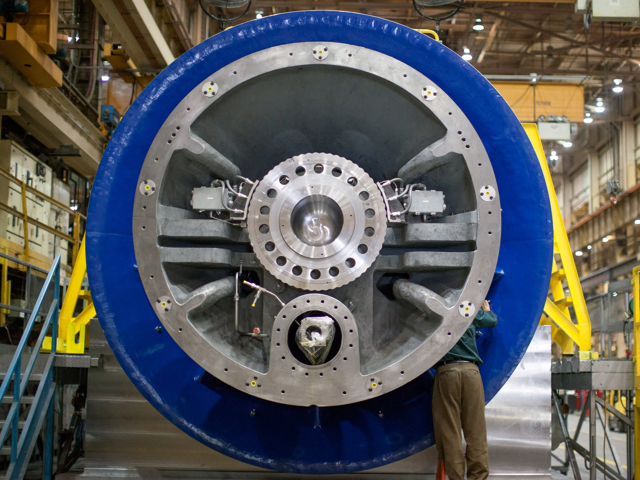 A worker checks on a component of an H-class gas turbine at the General Electric Co. Power &amp; Water plant in Greenville, South Carolina.
