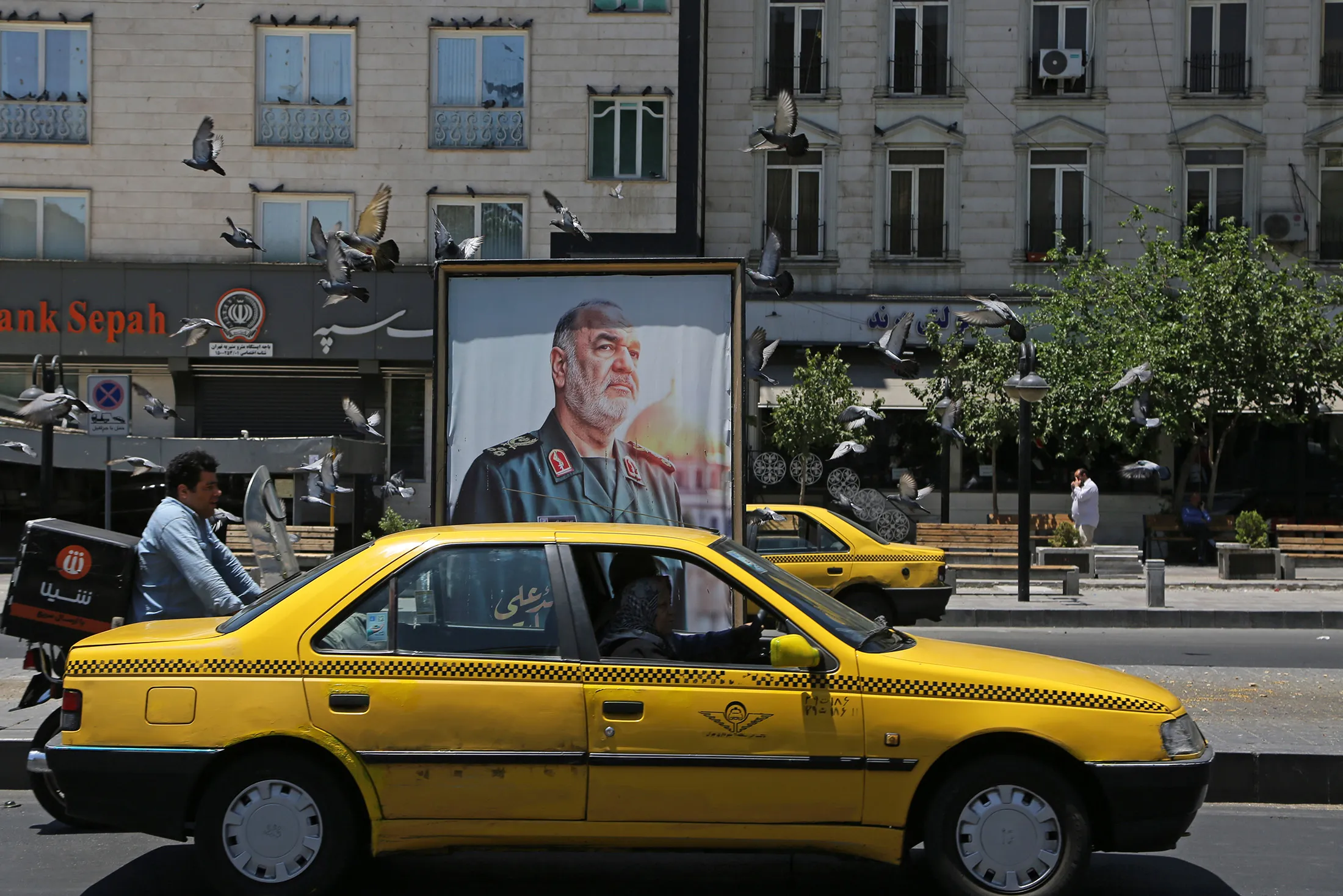 A poster&nbsp;bearing the image of Commander-in-Chief of the IRGC Hossein Salami, displayed in front of a Bank Sepah branch in&nbsp;Tehran on June 17.