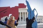 Activists at the Supreme Court opposed to partisan gerrymandering hold up representations of congressional districts from North Carolina and Maryland.