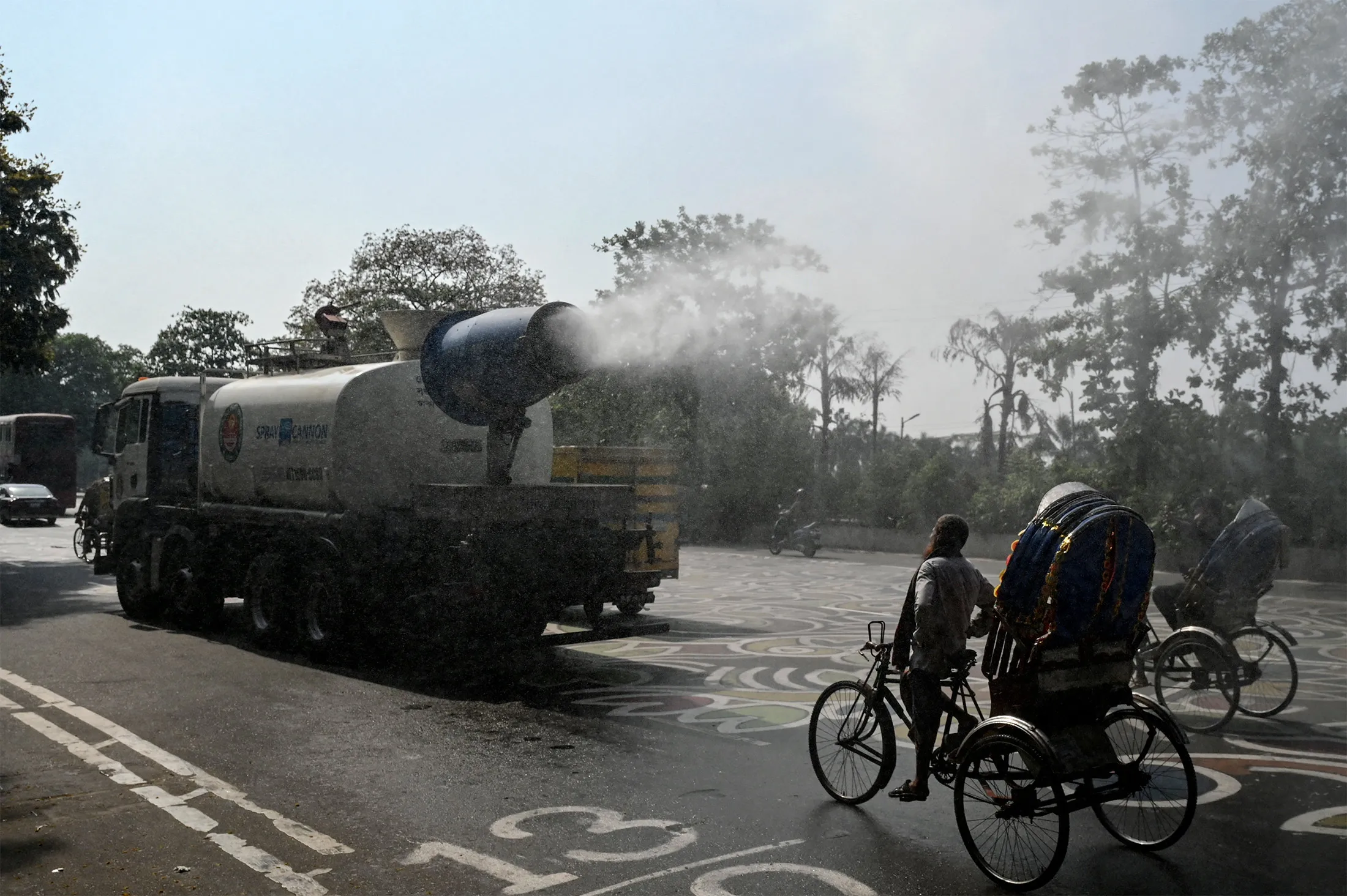A vehicle sprays water along a busy road to lower the temperature amidst a heat wave in Dhaka,&nbsp;Bangladesh, on April 27, 2024.