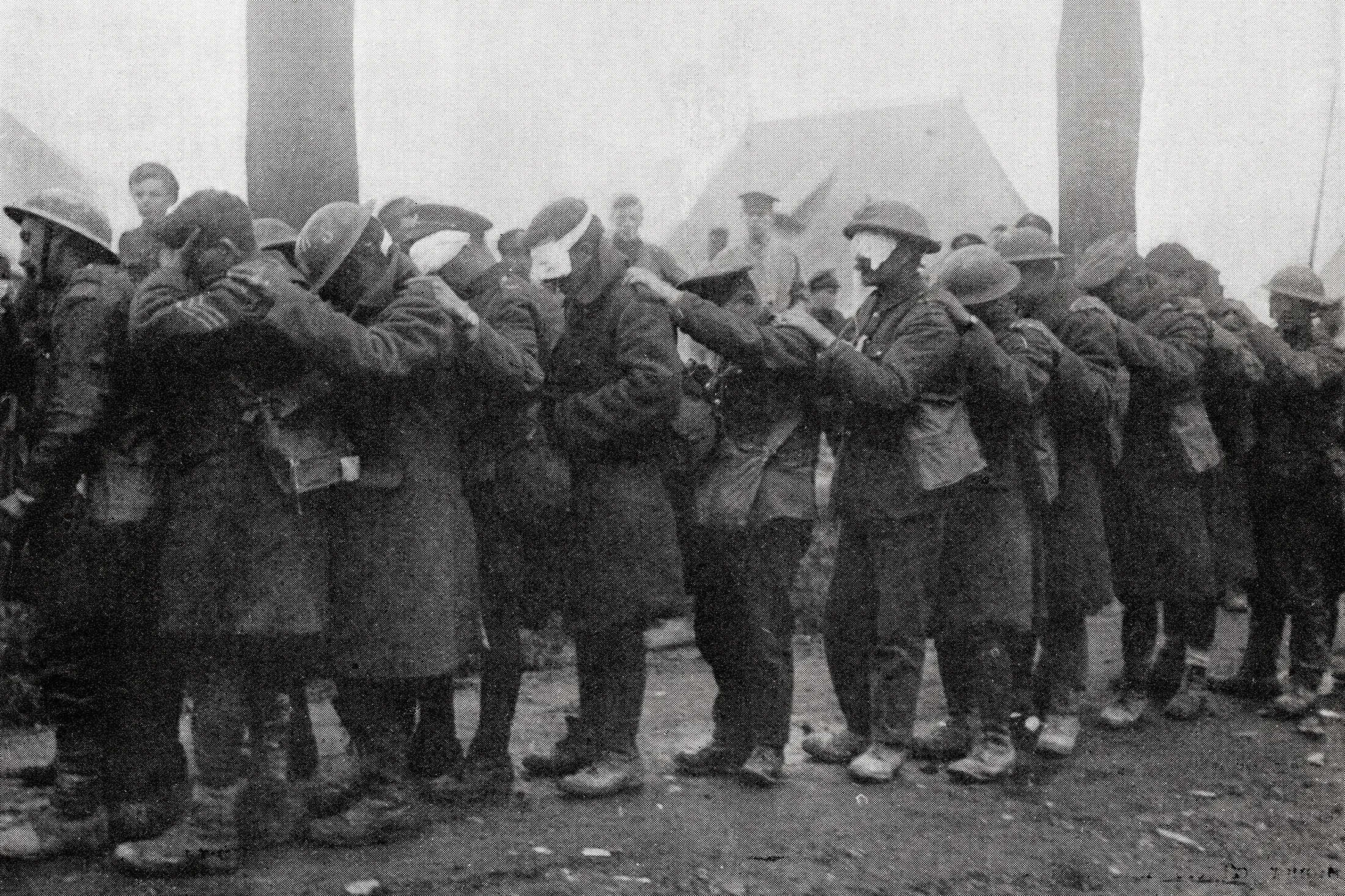 Soldiers blinded by mustard gas waiting for treatment outside an advanced dressing station near Bethune, after the Battle of Estaires, April 10th, 1918.&nbsp;