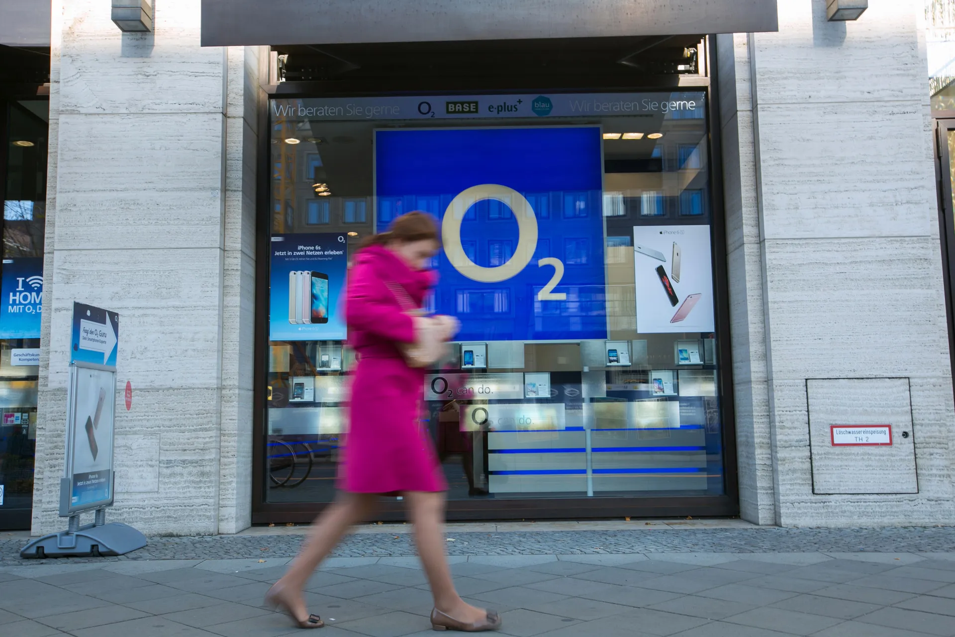 A pedestrian passes a O2 mobile phone store in Berlin.