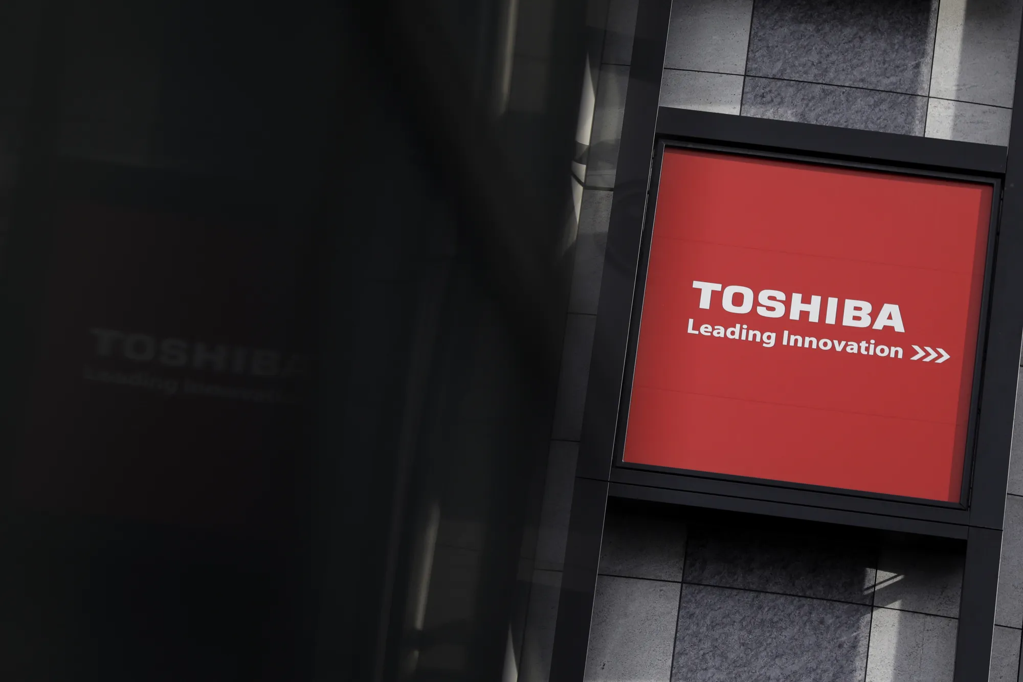 The Toshiba Corp. logo is displayed outside an electronics store in Tokyo, Japan, on Monday, Jan. 23, 2017. Toshiba's shares climbed the most in three weeks on Monday after reports that the company’s plan to sell a stake in its chip unit is drawing attention from possible investors.