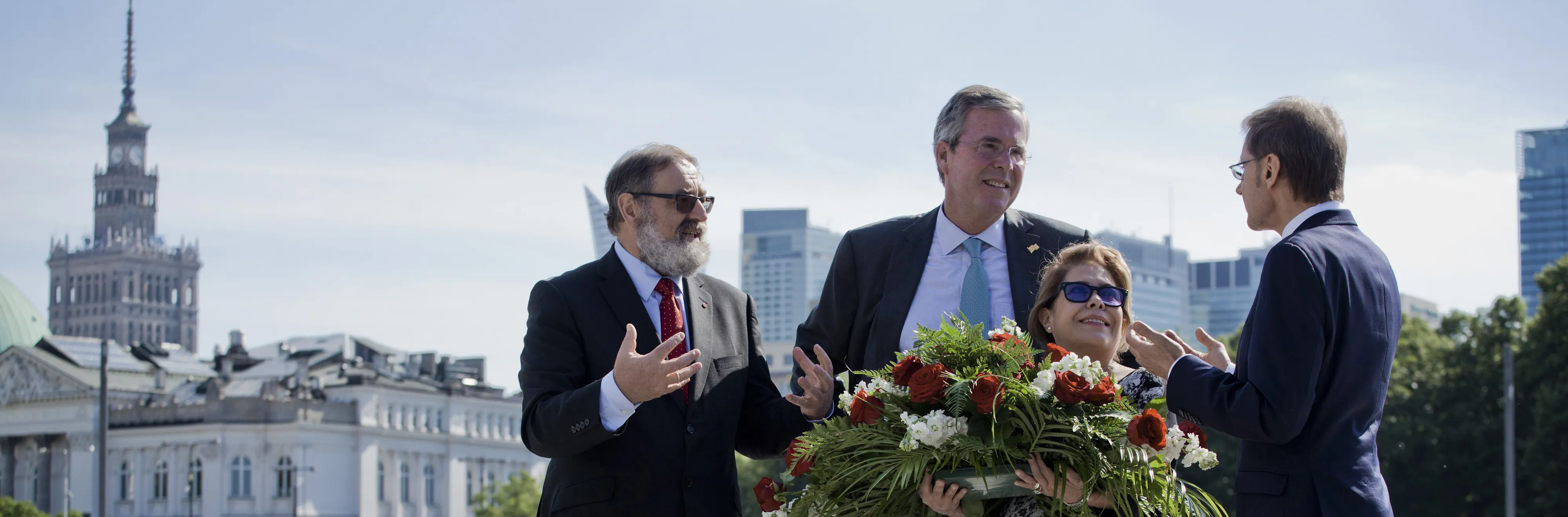 Jeb Bush, former governor of Florida, second left, lays a wreath with his wife Columba Bush, second right, and members of Polish American Freedom Foundation in Pilsudski Square in Warsaw, Poland, on Thursday, June 11, 2015. Jeb Bush is on a five-day European tour, followed by a presidential announcement in Miami.
