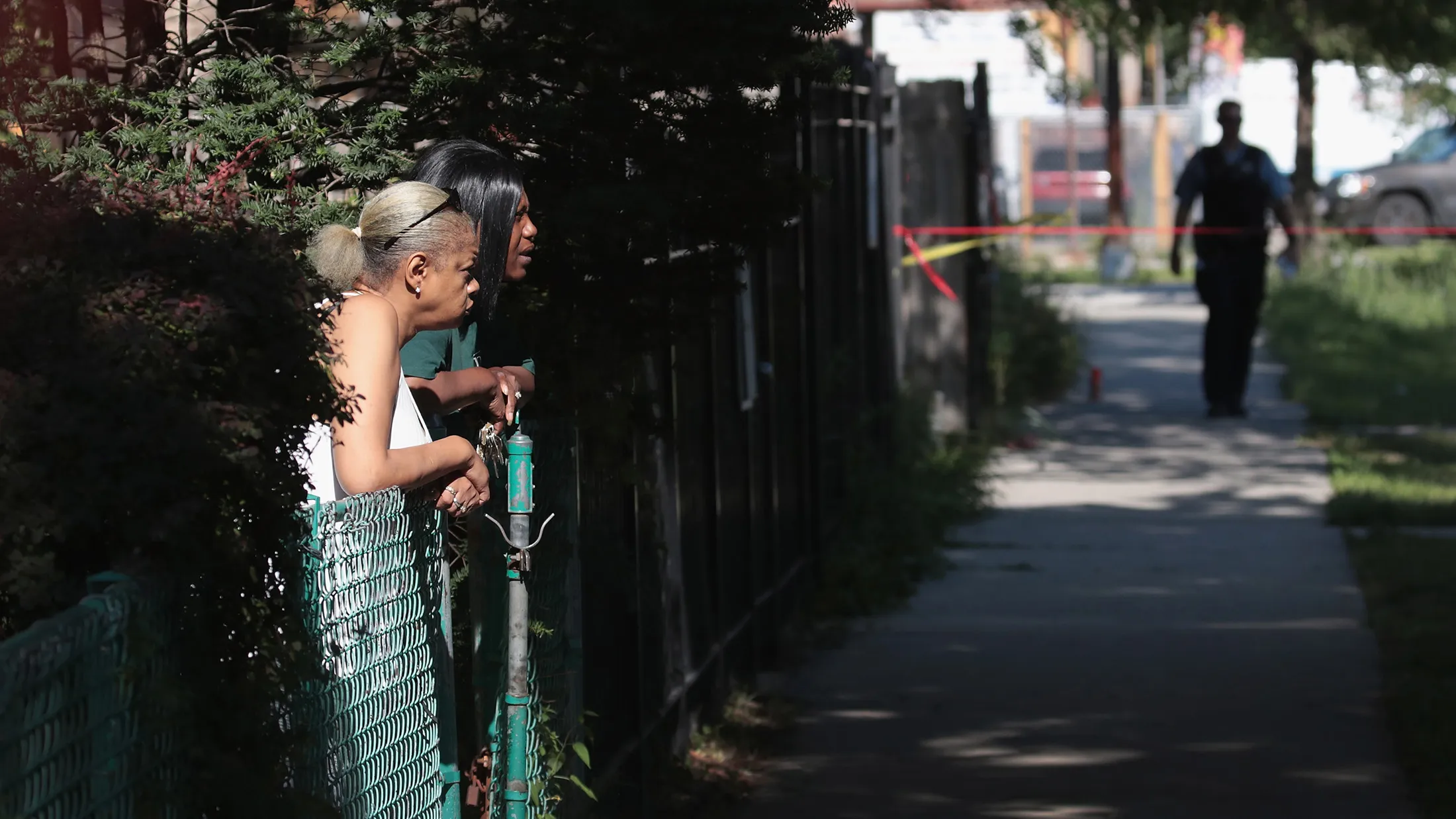 CHICAGO, IL - JULY 27: Residents watch as Chicago Police and police SWAT team members surround a house in the Humboldt Park neighborhood where they believe a man responsible for a nearby murder was hiding on July 27, 2017 in Chicago, Illinois. At least 400 murders have been recorded to date in 2017 in the Chicago. The city is on a pace to top last year's total of more than 750 murders, the highest the number since the early 1990's.

