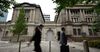 Pedestrians walk past the Bank of Japan (BOJ) headquarters in Tokyo, Japan, on Monday, July 8, 2019. Governor Haruhiko Kuroda said extremely low interest rates will be kept in place until at least around next spring while the bank will keep an eye on risks for price momentum.