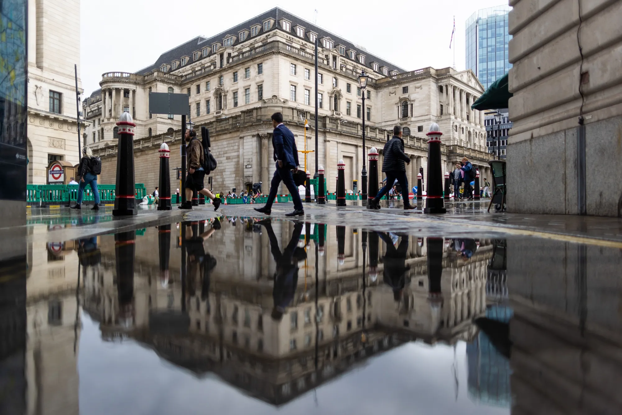 Commuters pass the Bank of England (BOE) in the City of London, UK.