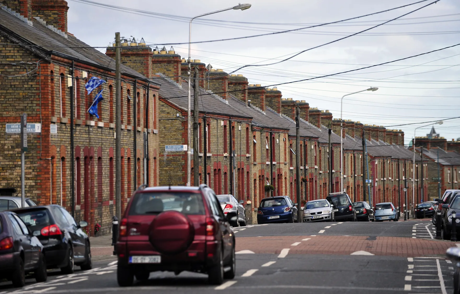 An automobile passes a row of brick terraced houses in Dublin, Ireland, on Wednesday, Sept. 18, 2013. Residential property prices in Dublin rose 8 percent in July from a year earlier, the Central Statistics Office reported last month.