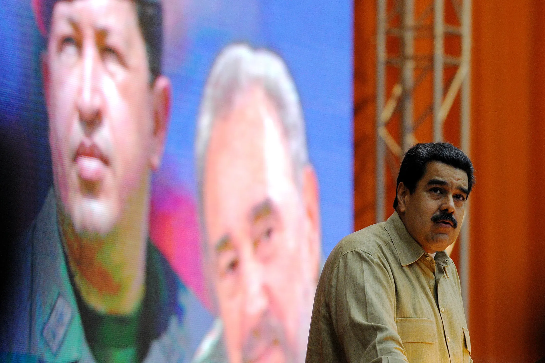 Nicolas Maduro speaks in front of an image of Chavez and Castro in Havana in 2016.