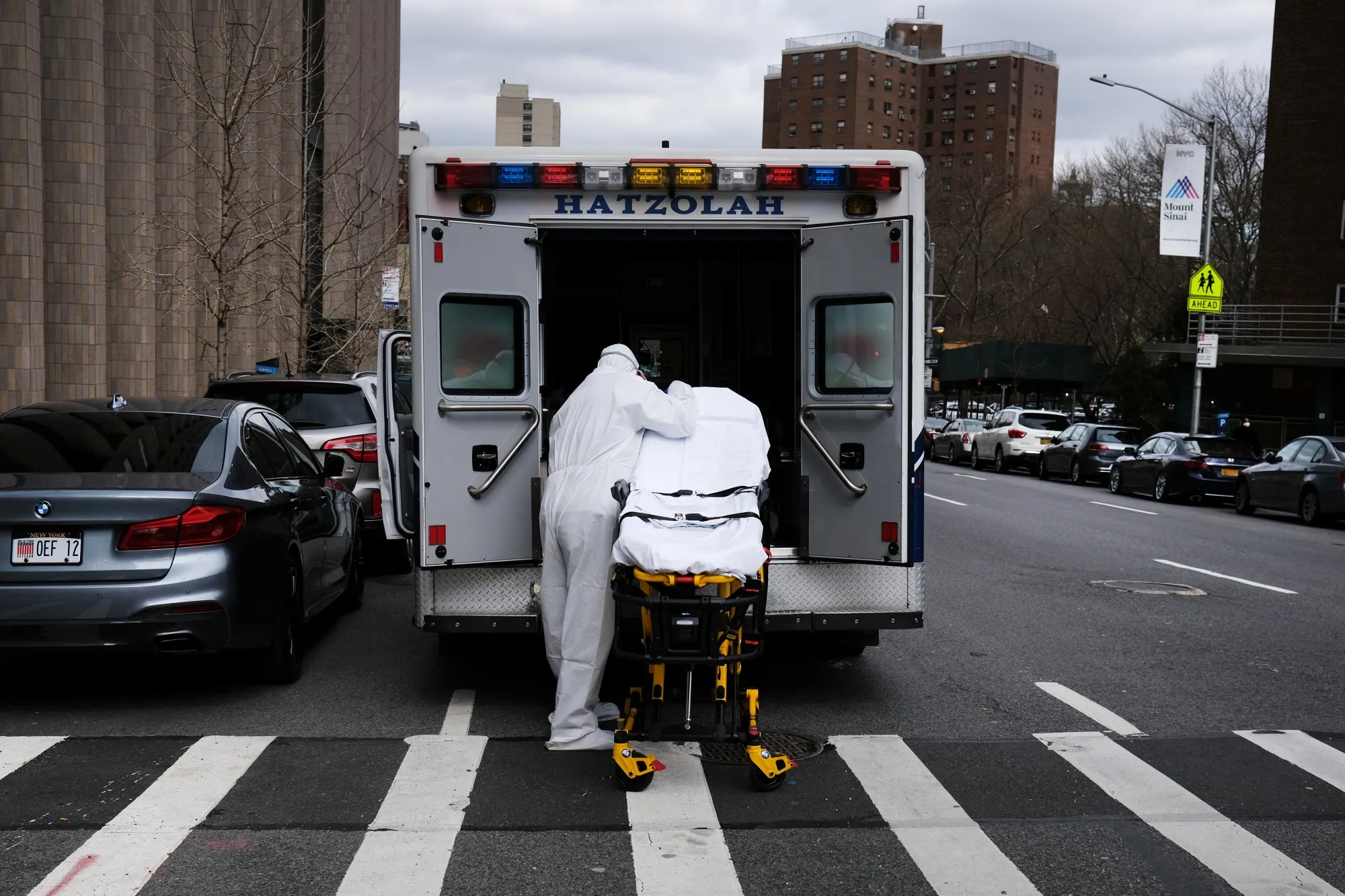 An ambulance driver puts away and cleans a medical gurney outside of Mount Sinai Hospital in New York on March 31.