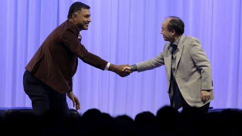 Billionaire Masayoshi Son, chairman and chief executive officer of SoftBank Group Corp., right, shakes hands with Nikesh Arora, president and chief operating officer of SoftBank Group Corp.