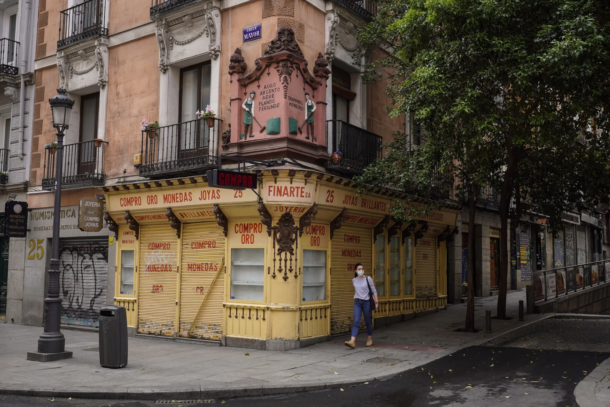 A pedestrian walks along Calle Mayor past shuttered stores and cafes in Madrid, on&nbsp;May 7.