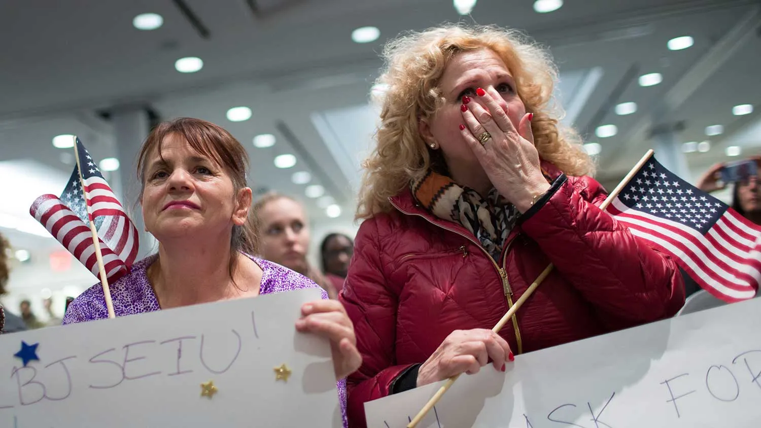 Fadila Mrkulic (L) and Tatiana Lambert react the offices of 32BJ SEIU, a workers union, during a viewing party for U.S. President Barack Obama's speech on evecutive action immigration policy reform on November 20, 2014 in New York City.
