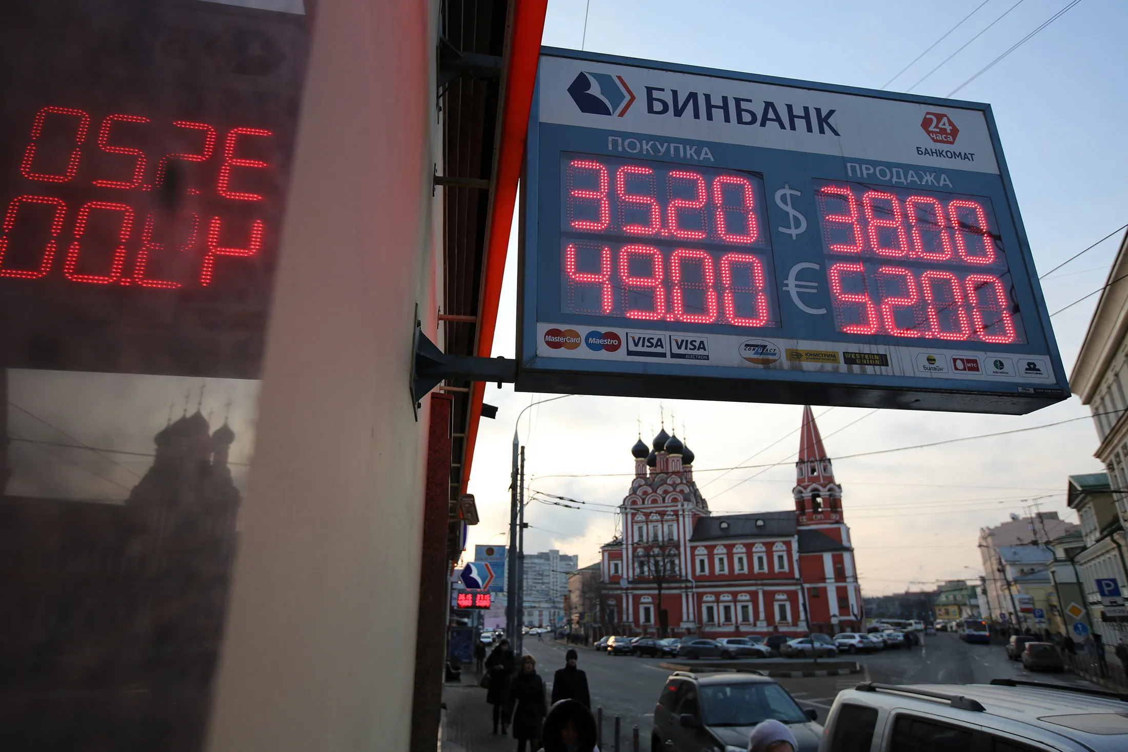 An electronic sign advertises foreign exchange rates for dollars and euros outside an OAO B&amp;N Bank branch in Moscow.
