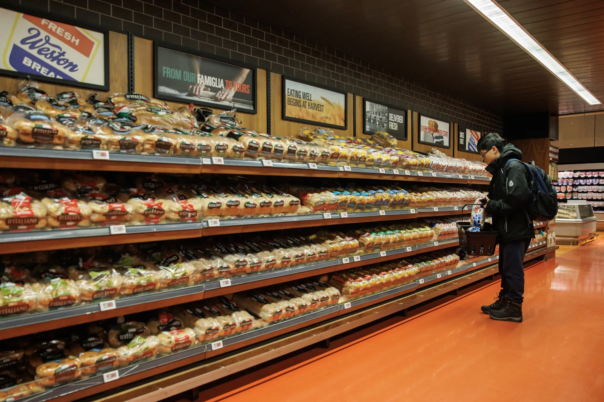 A shopper in the bread aisle at a grocery store.