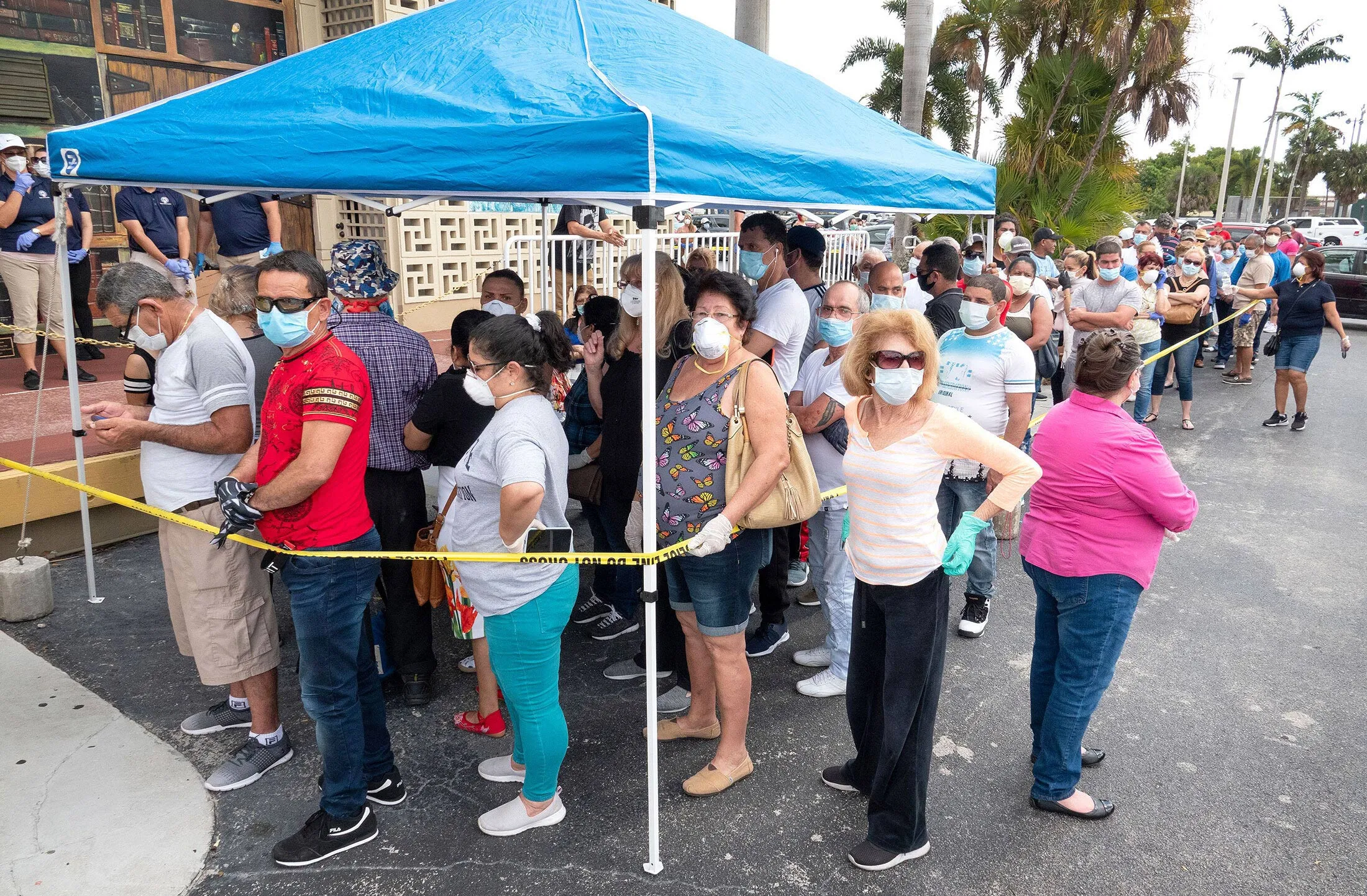 People wait in line for printed unemployment benefit applications in Hialeah, Fla., on April 7.