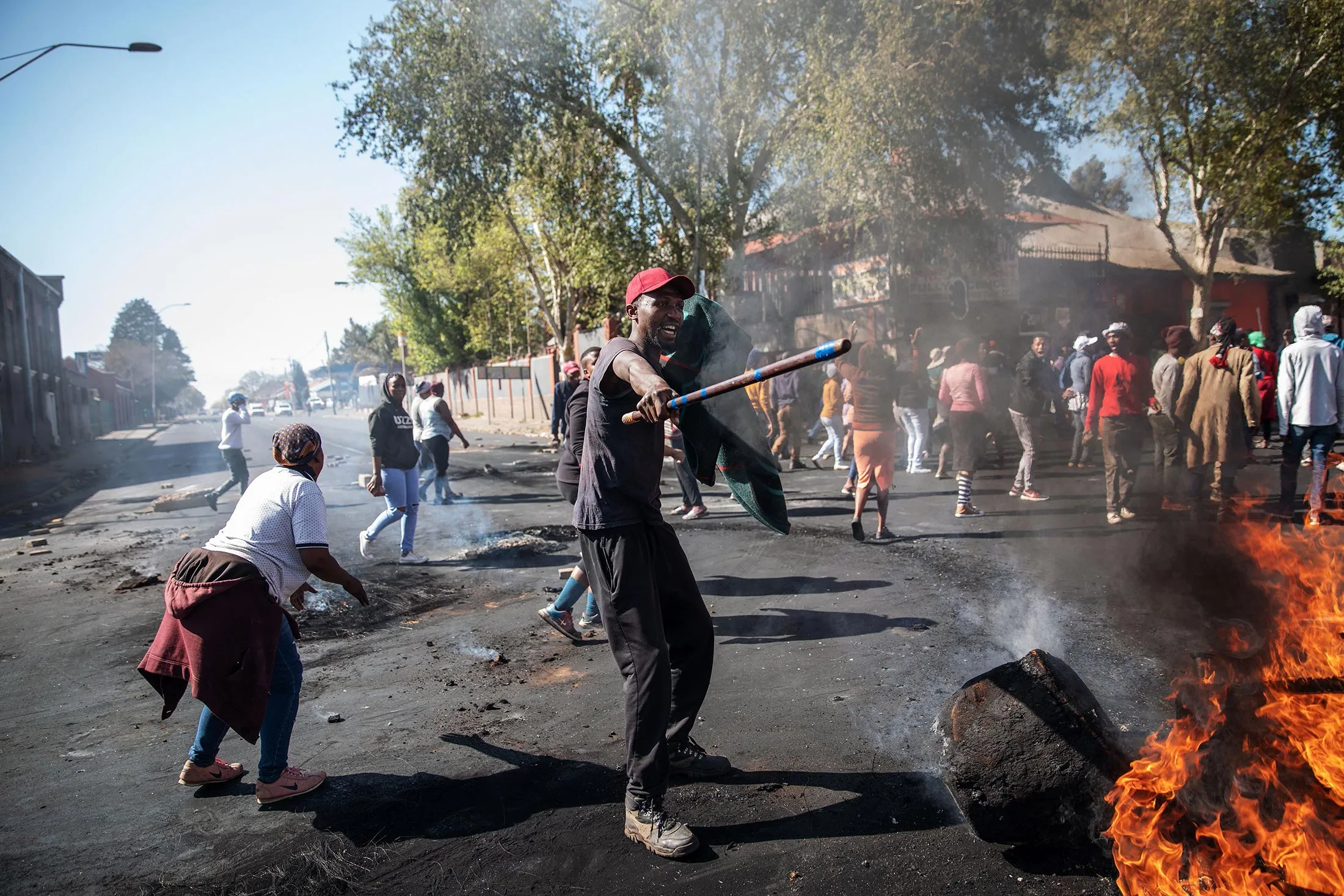 A man waves a stick in front a burning piece of furniture during a riot in the Johannesburg suburb of Turffontein on Sept. 2.